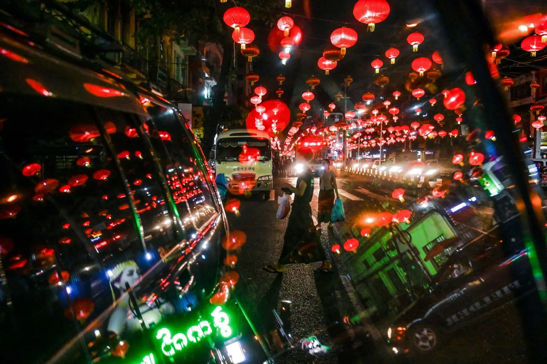 La gente camina bajo linternas decorativas antes del Año Nuevo chino en el barrio chino de Yangon. AFP