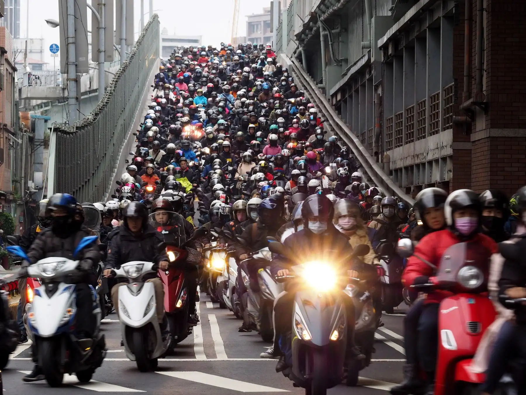 Cientos de personas cruzan el puente Taipei en motocicleta para ir a trabajar este viernes en Taipei. La gran cantidad de motocicletas que baja al mismo tiempo por el puente Taipei ha sido llamada "cascada de motocicletas" y ha atraído a turistas y fotógrafos que quieren ver el espectáculo matutino. EFE