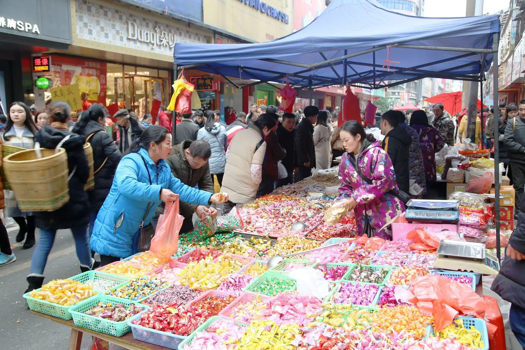 Imagen de clientes comprando dulces en un mercado en el Condado Autónomo Dong de Yuping de la ciudad de Tongren, provincia de Guizhou, en el suroeste de China. Las personas están ocupadas comprando artículos en Guizhou para el próximo Festival de Primavera, que cae el 5 de febrero este año. (Xinhua/Liu Dejun)