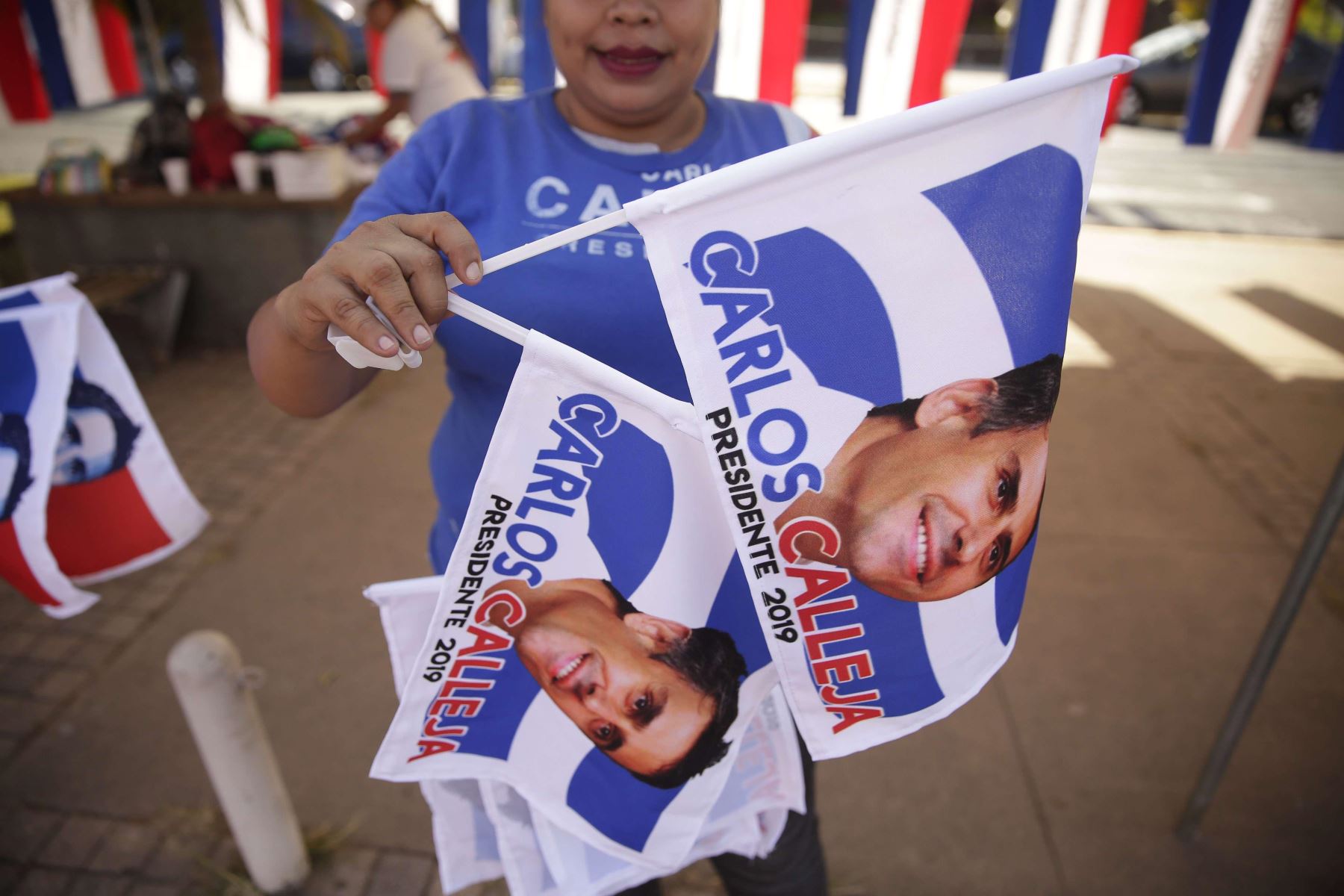 Una mujer muestra este martes banderas de la Alianza Republicana Nacionalista (Arena), en San Salvador (El Salvador). Foto: EFE