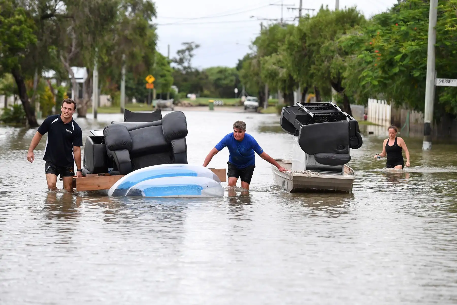 Residentes usan un bote y una colchoneta hinchable para trasladar parte de sus muebles, durante las inundaciones en Townsville, en el estado australiano de Queensland.. EFE