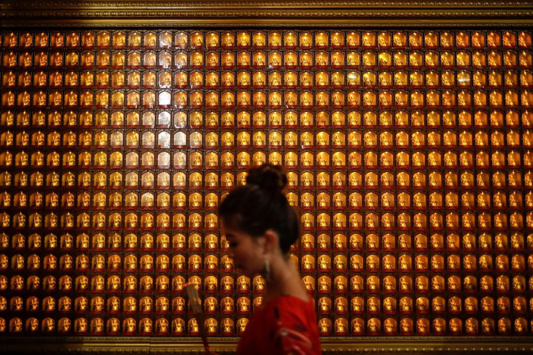 Una mujer pasa junto a un conjunto de estatuillas religiosas en el templo de la deidad taoísta Loyang Tua Pek Kong en Singapur este lunes. La llegada este martes del Año Nuevo Lunar trae variopintas supersticiones en varios países de Asia, como decorar las calles, cortarse el pelo, vestirse con prendas de color rojo y limpiar las casas para ahuyentar los malos espíritus. EFE