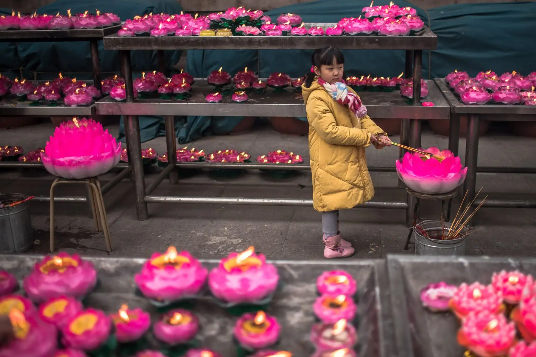 Una niÒa quema incienso junto a varias velas en un templo budista este miércoles durante las celebraciones por el Año nuevo lunar en el parque Badachu de PekÌn (China). EFE