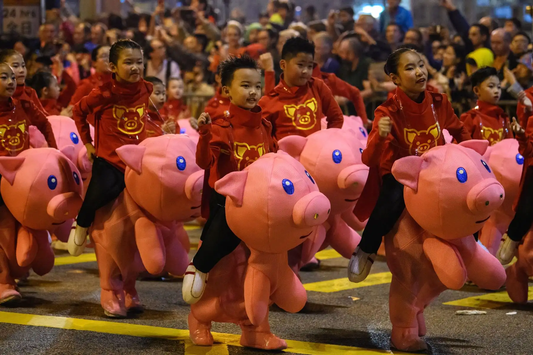 Los niños pequeños se presentan con disfraces de cerdo cuando participan en el desfile anual del Año Nuevo Lunar en el distrito Kowloon de Hong Kong, para conmemorar el Año del Cerdo.