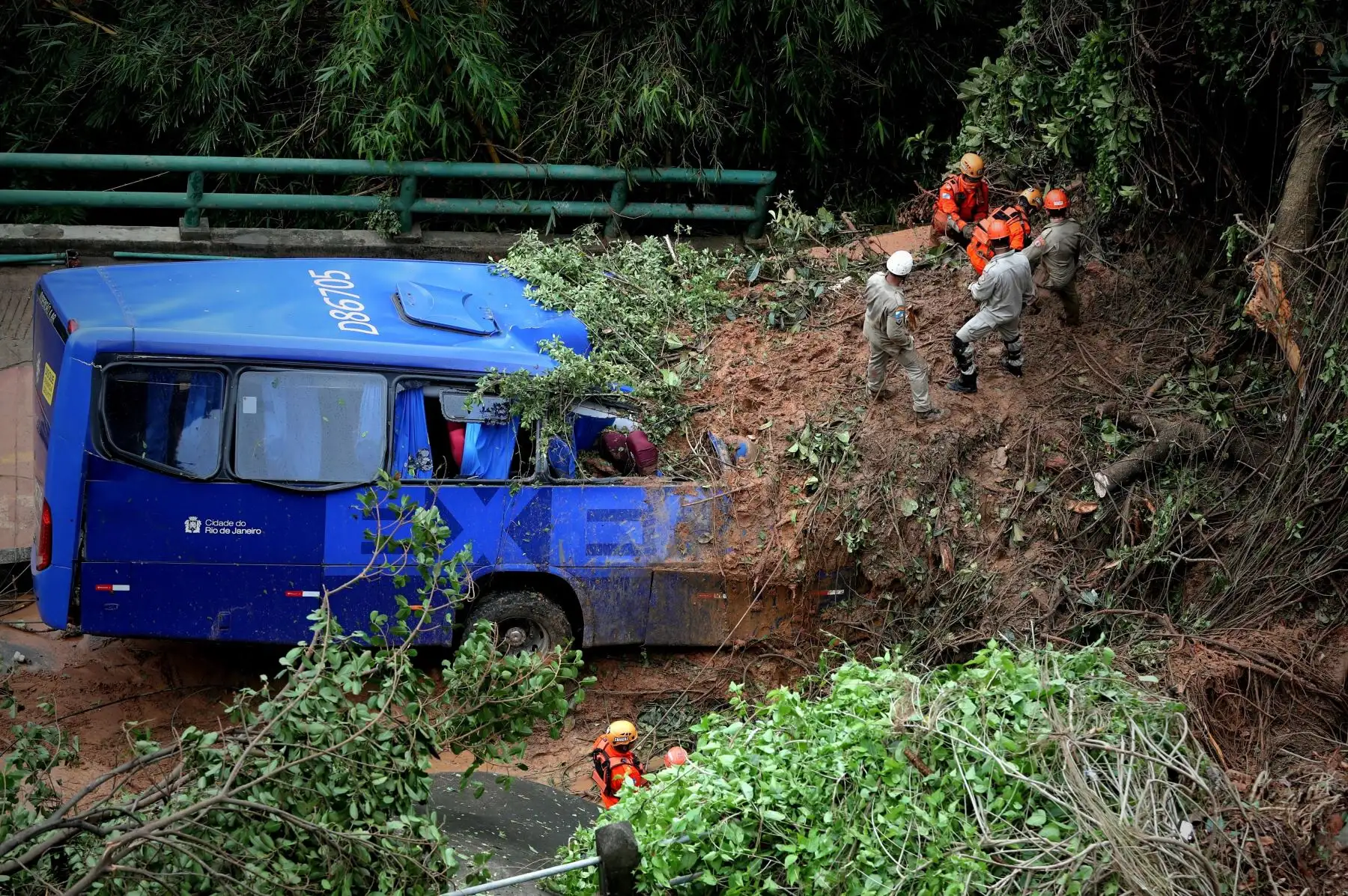 Equipos de emergencia trabajan en el lugar donde un autobus ha quedado sepultado por un deslizamiento de tierra este miércoles, en la avenida Niemeyer de RÌo de Janeiro (Brasil). Al menos tres personas murieron y otras dos están desaparecidas debido a la fuerte tempestad de lluvia y viento que arreció durante la noche del miércoles en la ciudad de RÌo de Janeiro, informaron fuentes oficiales. En la zona oeste de la capital fluminense, dos personas murieron y otras dos resultaron heridas tras derrumbarse u