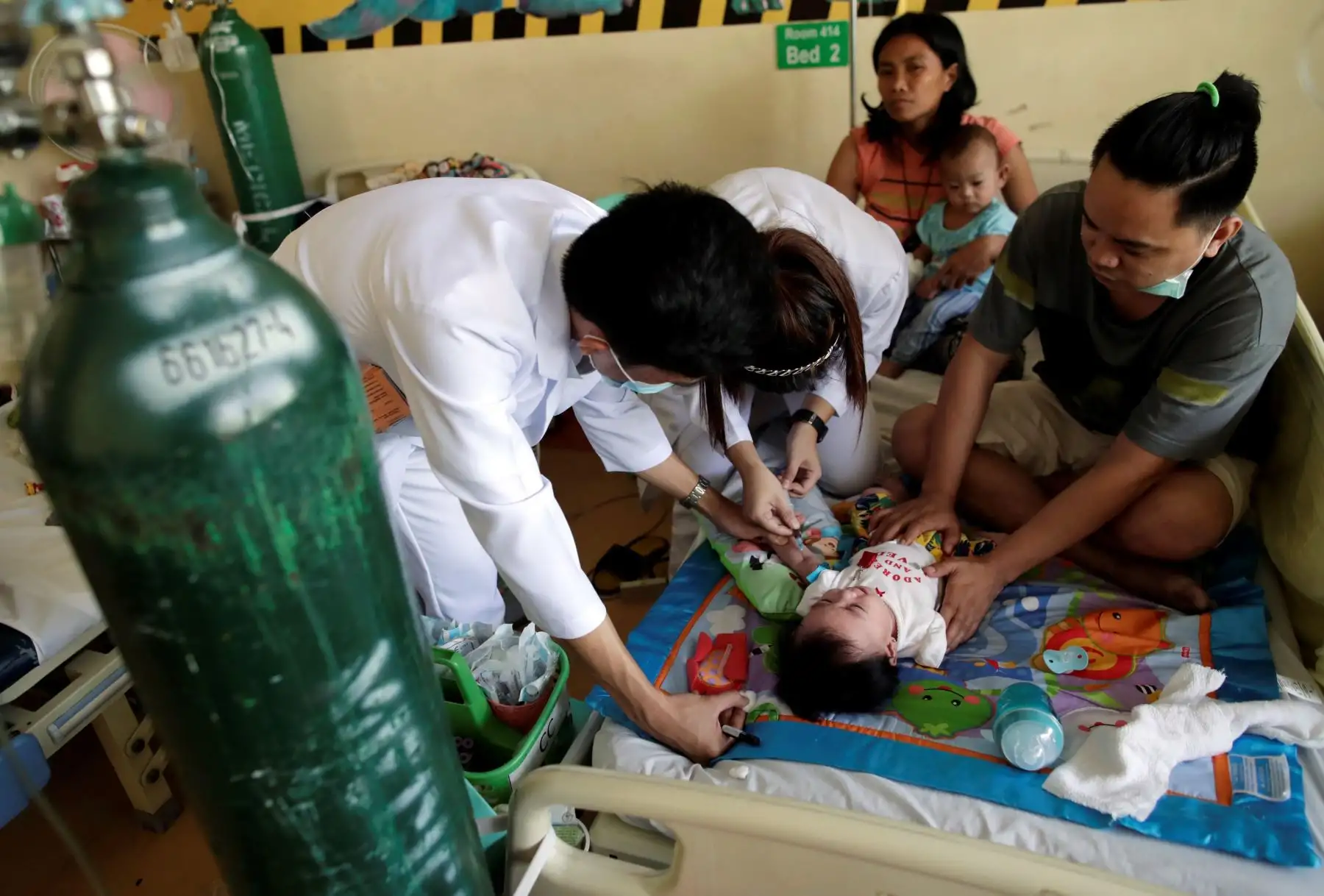 Doctores filipinos atienden a un niño enfermo de sarampión, este jueves, en Manila, Filipinas. Foto: EFE