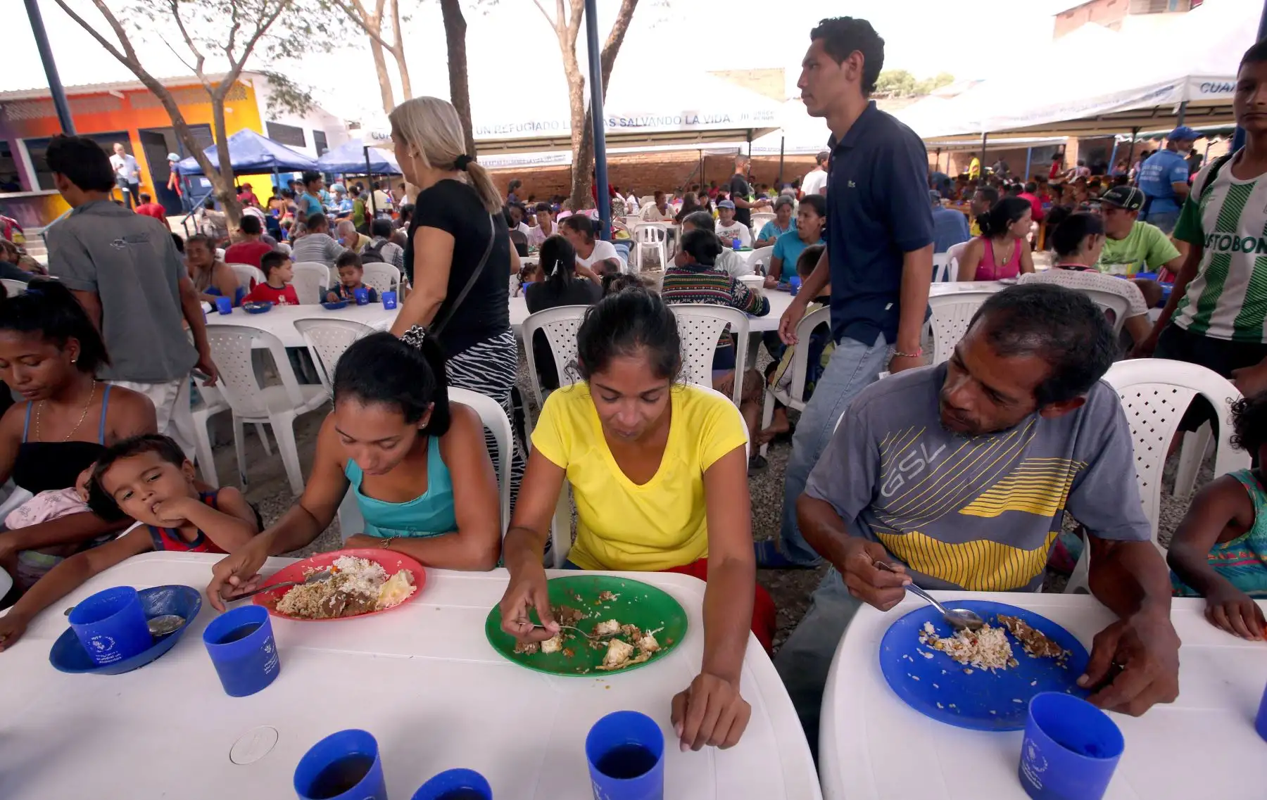 Ciudadanos venezolanos comen tras recibir una ración de comida en el comedor Divina Providencia, en Cúcuta (Colombia). EFE