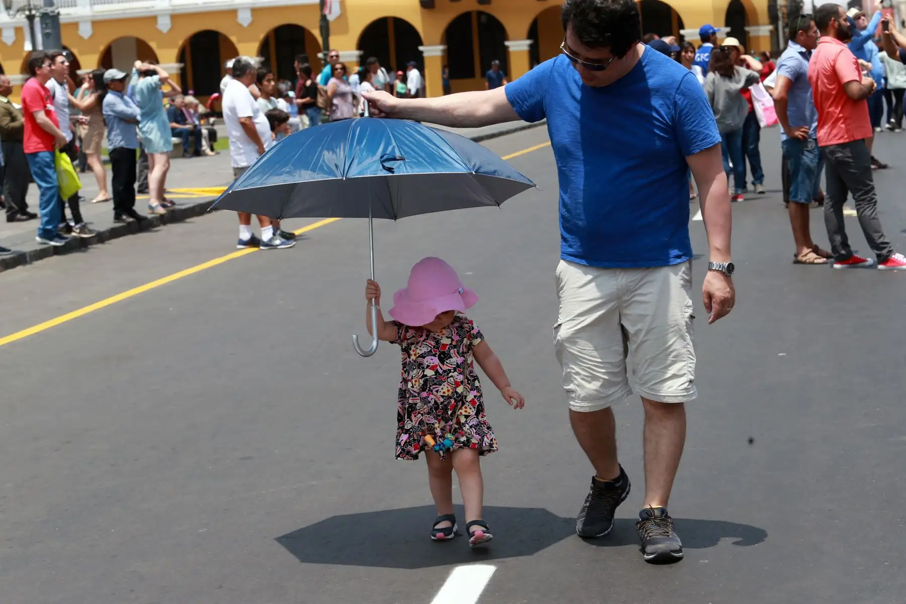 Una pequeña niña es protegida del sol por su padre mientras pasean por la Plaza Mayor de Lima. Foto: ANDINA/Norman Córdova