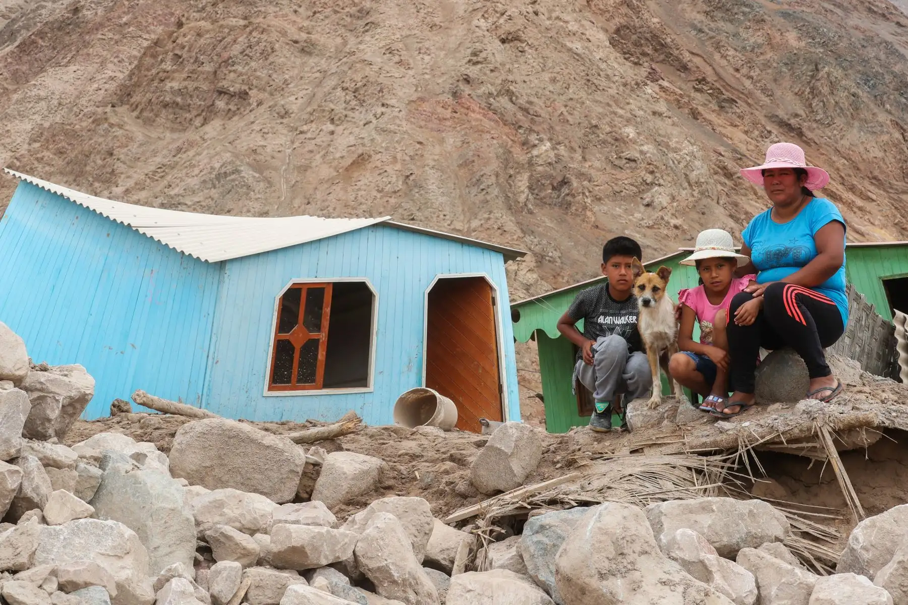 Una madre con sus hijos, lo han perdido todo con el huaico, ahora a pesar de la tristeza sabe que debe ser fuerte por sus niños.
Foto: ANDINA/Juan Carlos Guzmán Negrini.