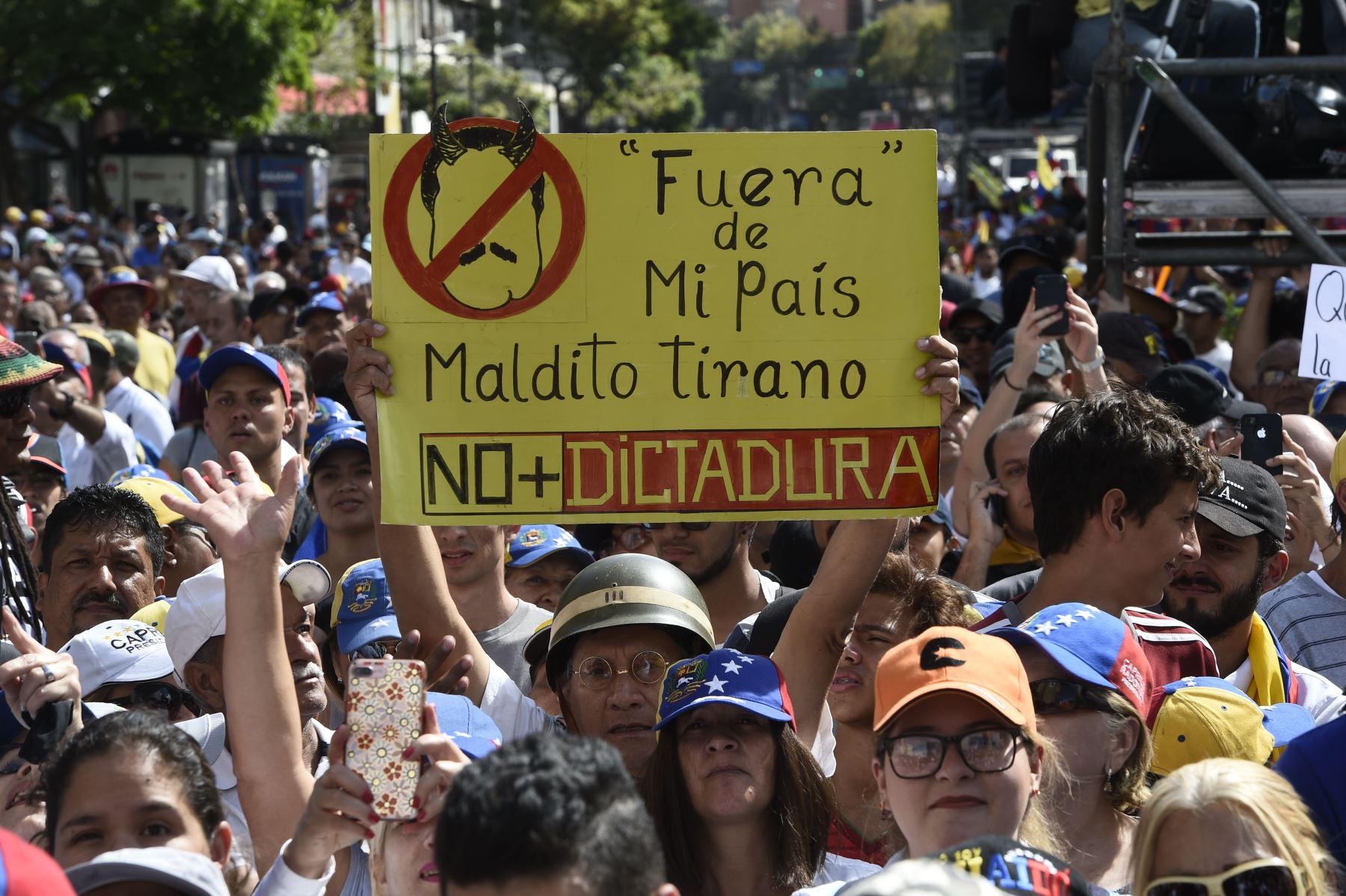 Partidarios del líder opositor venezolano y autodeclarado presidente Juan Guaido, muestra un cartel que dice "Salga de mi país, maldito tirano", "No más dictadura", refiriéndose al presidente Nicolás Maduro Foto: AFP