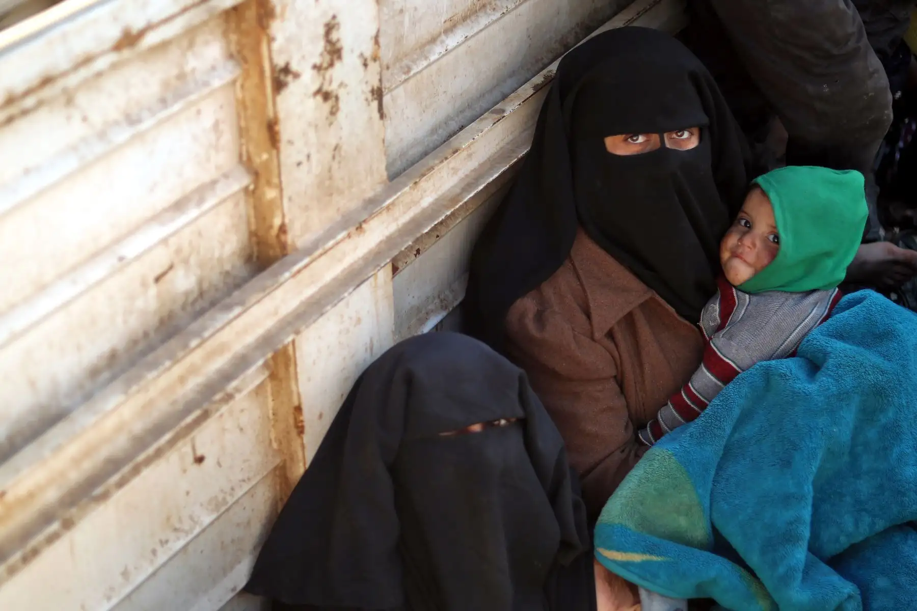 Civiles que huyen de provincia de Deir Ezzor, en el este de Siria, se sientan en la parte trasera de un camión. - Los combatientes apoyados por las Fuerzas Democráticas Sirias (SDF) respaldados por Estados Unidos lucharon hoy contra una feroz lucha jihadista. mientras empujaban a recuperar un último trozo de territorio del grupo del Estado Islámico. AFP