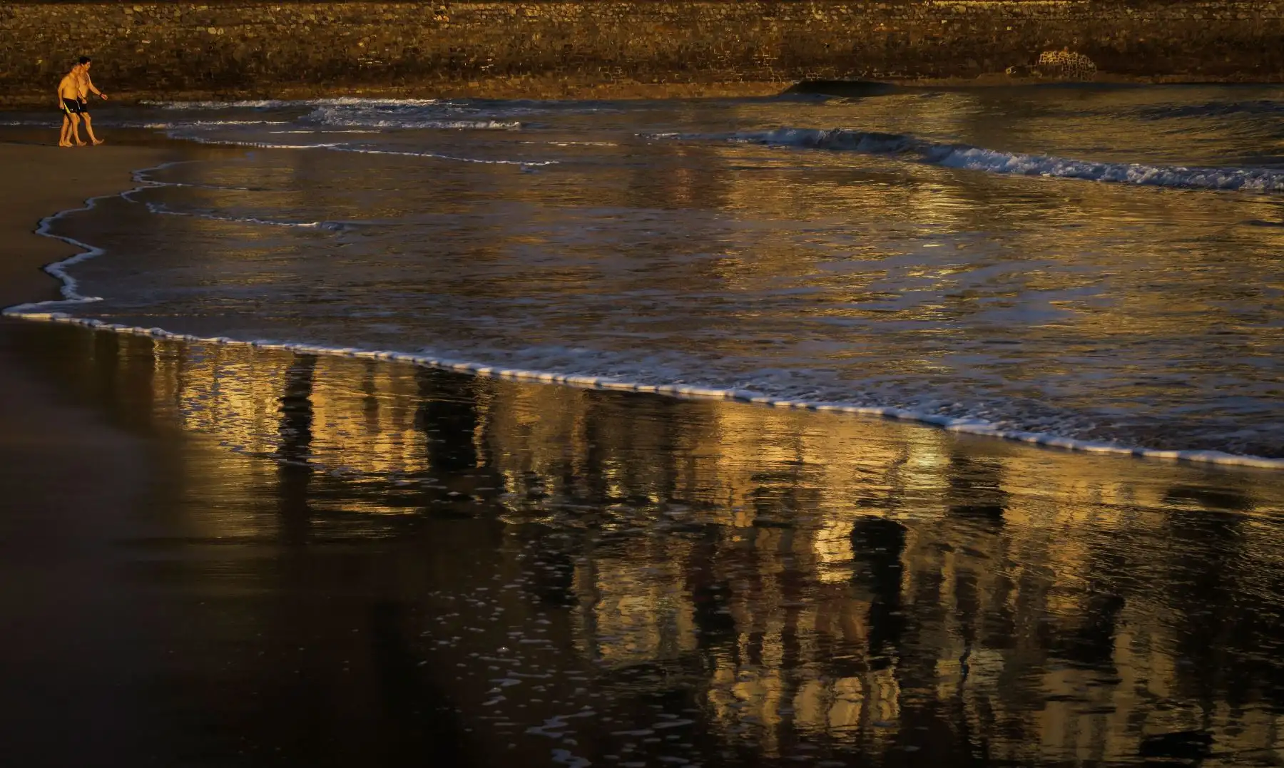 Dos hombres se bañan al amanecer en la playa de Ondarreta de San Sebastian, donde los cielos se presentan  despejados, con heladas débiles en el interior, las temperaturas máximas y en ascenso mientras que los vientos soplán flojos del este con intervalos  intensos de madrugada en la costa y flojos del sur y del sureste en el interior. EFE