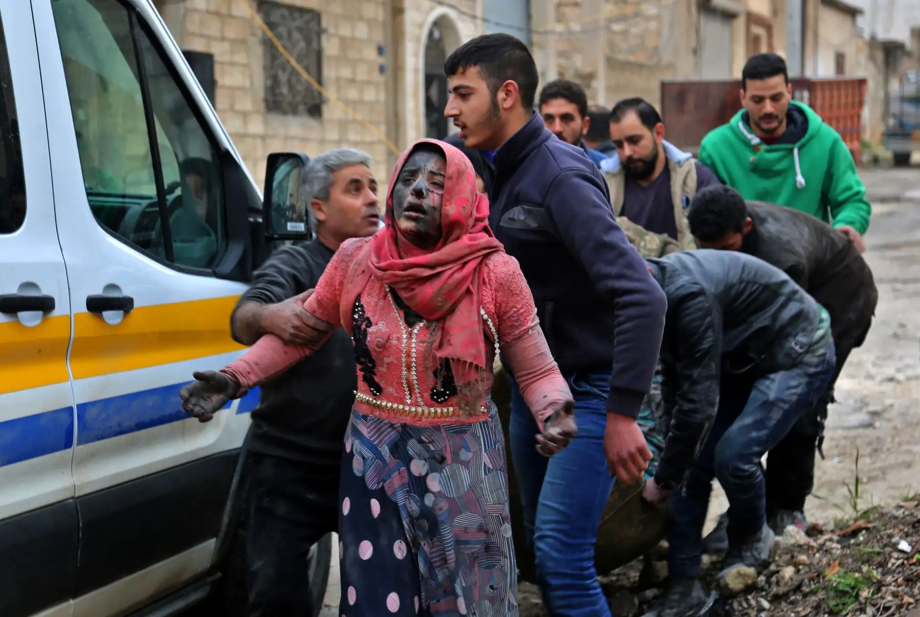 Hombres sirios ayudan a una mujer herida cubierta de polvo tras un ataque en la ciudad de Khan Shaykhun, en el campo sur de la provincia de Idlib, controlada por los rebeldes. AFP