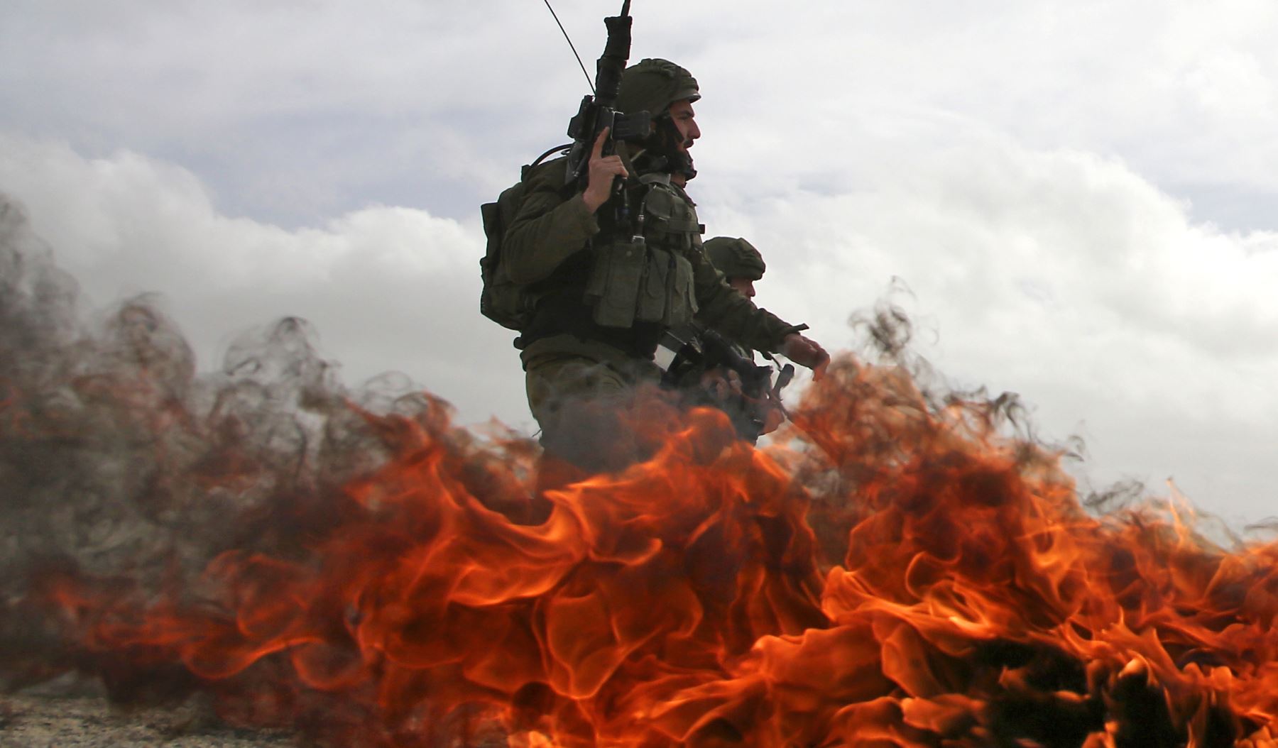Soldados israelíes pasan junto a neumáticos en llamas durante enfrentamientos con manifestantes palestinos luego de una manifestación contra asentamientos judíos en la aldea de Urif en Cisjordania, al sur de Nablus. AFP