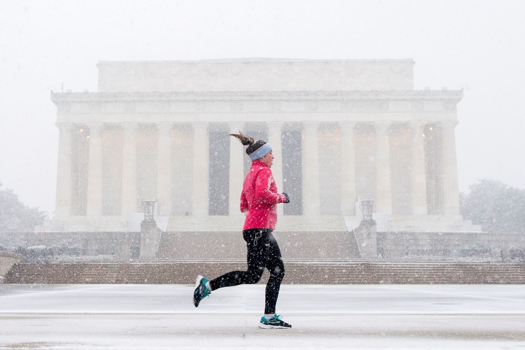 Una mujer corre frente al Memorial de Lincoln en Washington D.C (Estados Unidos), este miÈrcoles, durante una jornada de intensa nieve y bajas temperaturas. Foto: EFE