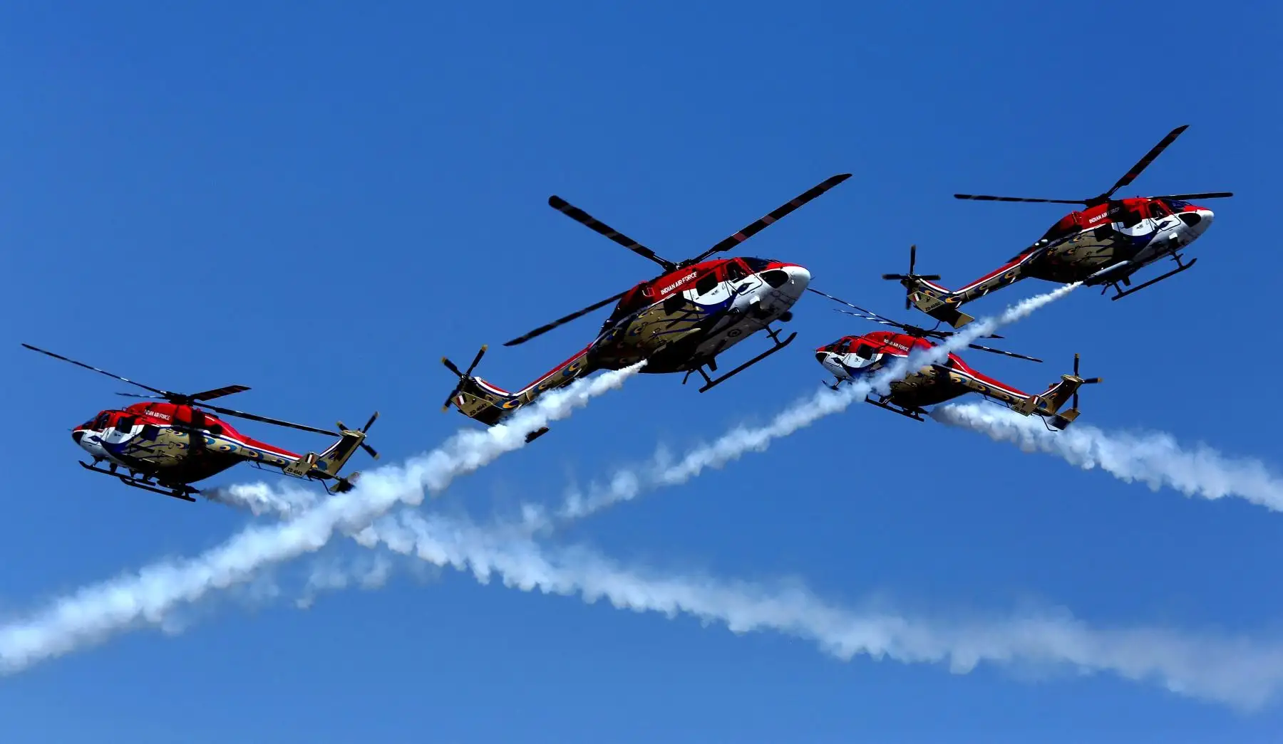 Varios helicópteros del equipo Sarang de la Fuerza Aérea india hacen una demostración acrobática  durante la inauguración de la XII edición de la feria de aviación Aero India en Bangalore (India). EFE