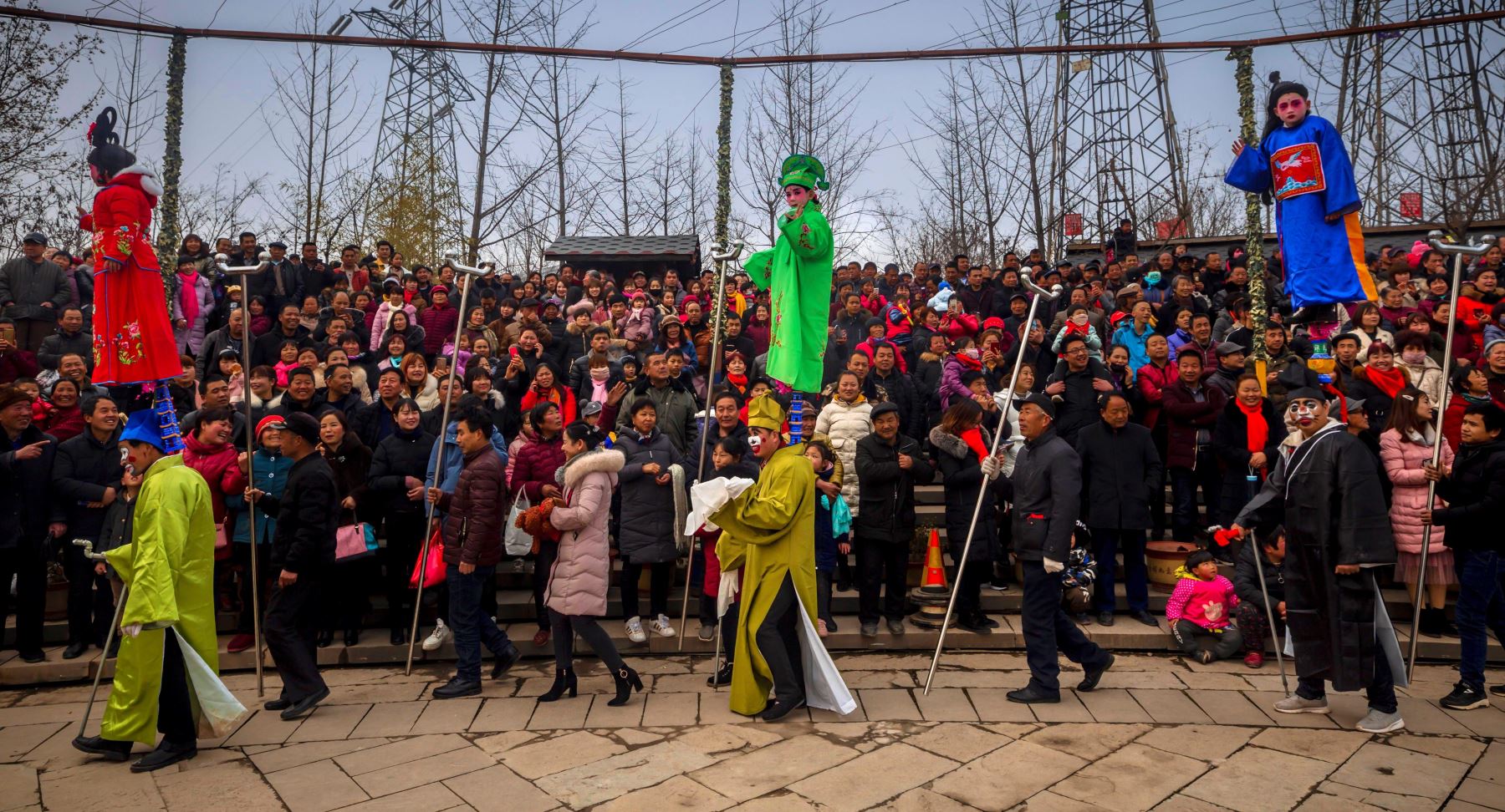 Personas usan trajes tradicionales frente a los aldeanos este lunes durante una celebración del Festival de los Faroles y del Año Nuevo Chino en el condado de Zhouzhi, provincia de Shaanxi, (China). Foto: EFE
