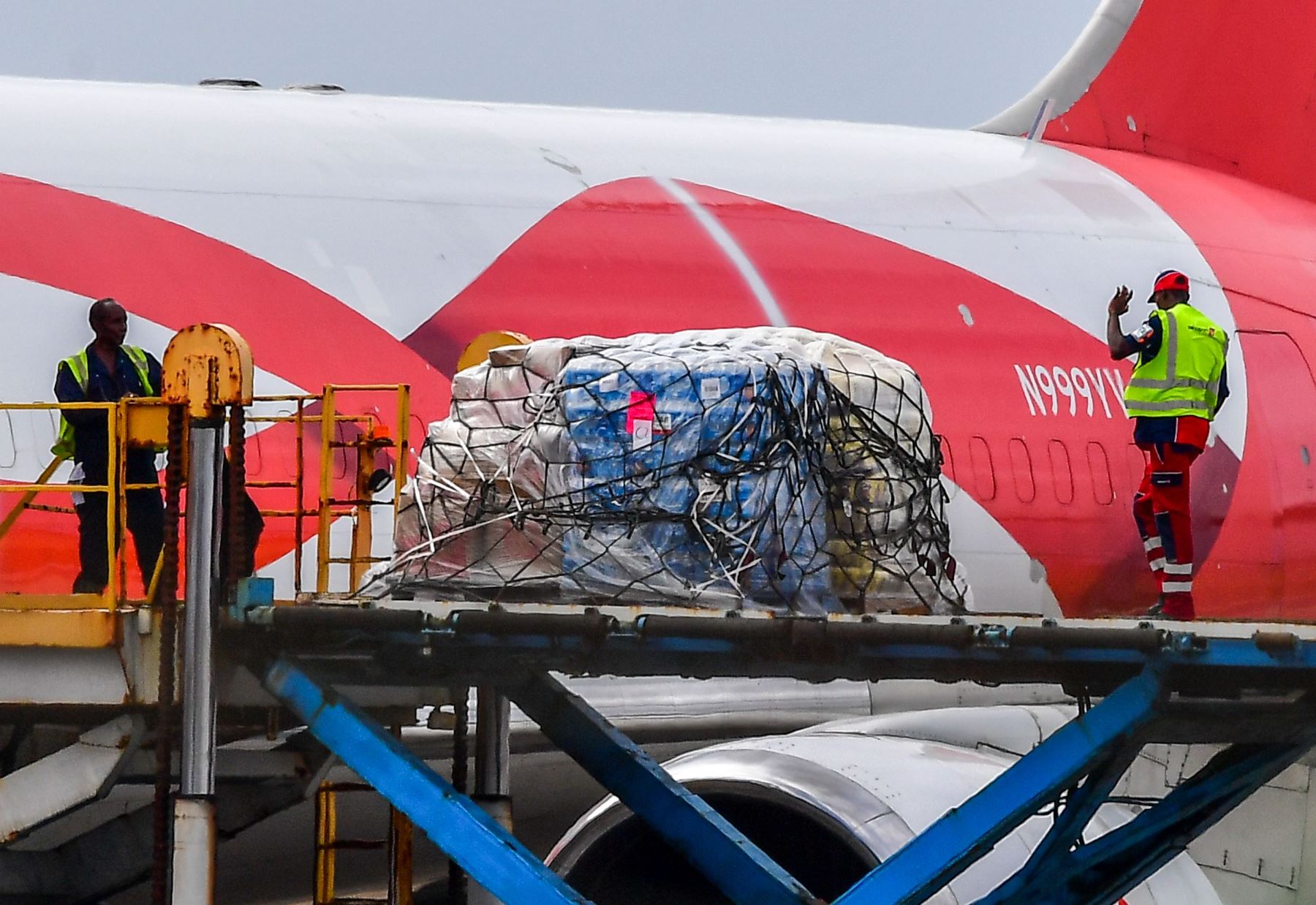 Los trabajadores cargan alimentos y asistencia médica para Venezuela desde un avión Boeing 767 de EE. UU.. en el aeropuerto internacional Hato, en Willemstad, Curazao. Foto: AFP.