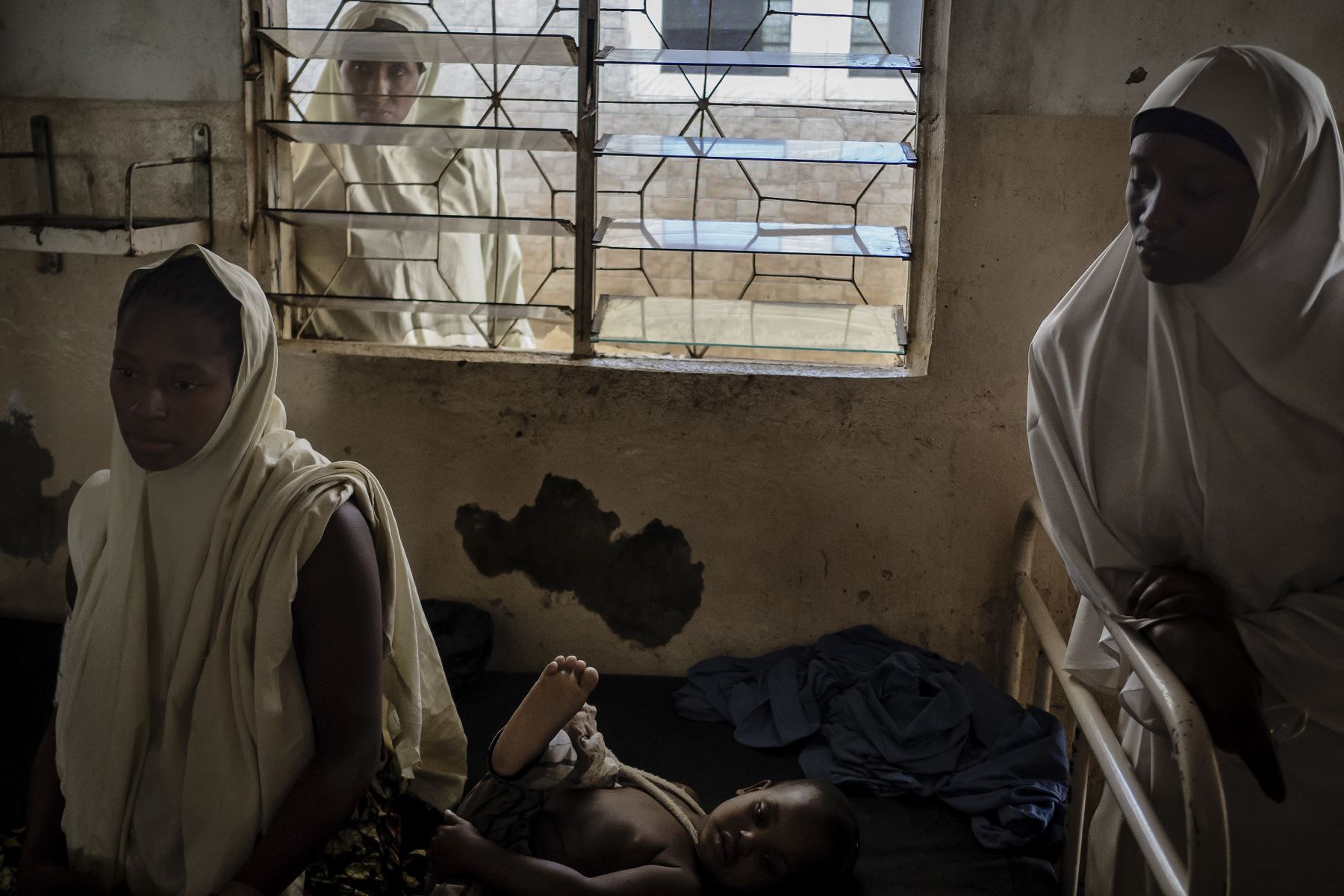 Husaina Saidu  y su hijo, que sobrevivieron a la semana pasada al ataque en el noroeste de Nigeria, se sientan en el Hospital JNI Muslim y en el Hogar de Maternidad en Kaduna. Un ataque de hombres armados en aldeas de Kajuru cobro  "más de 130" vidas.  AFP
