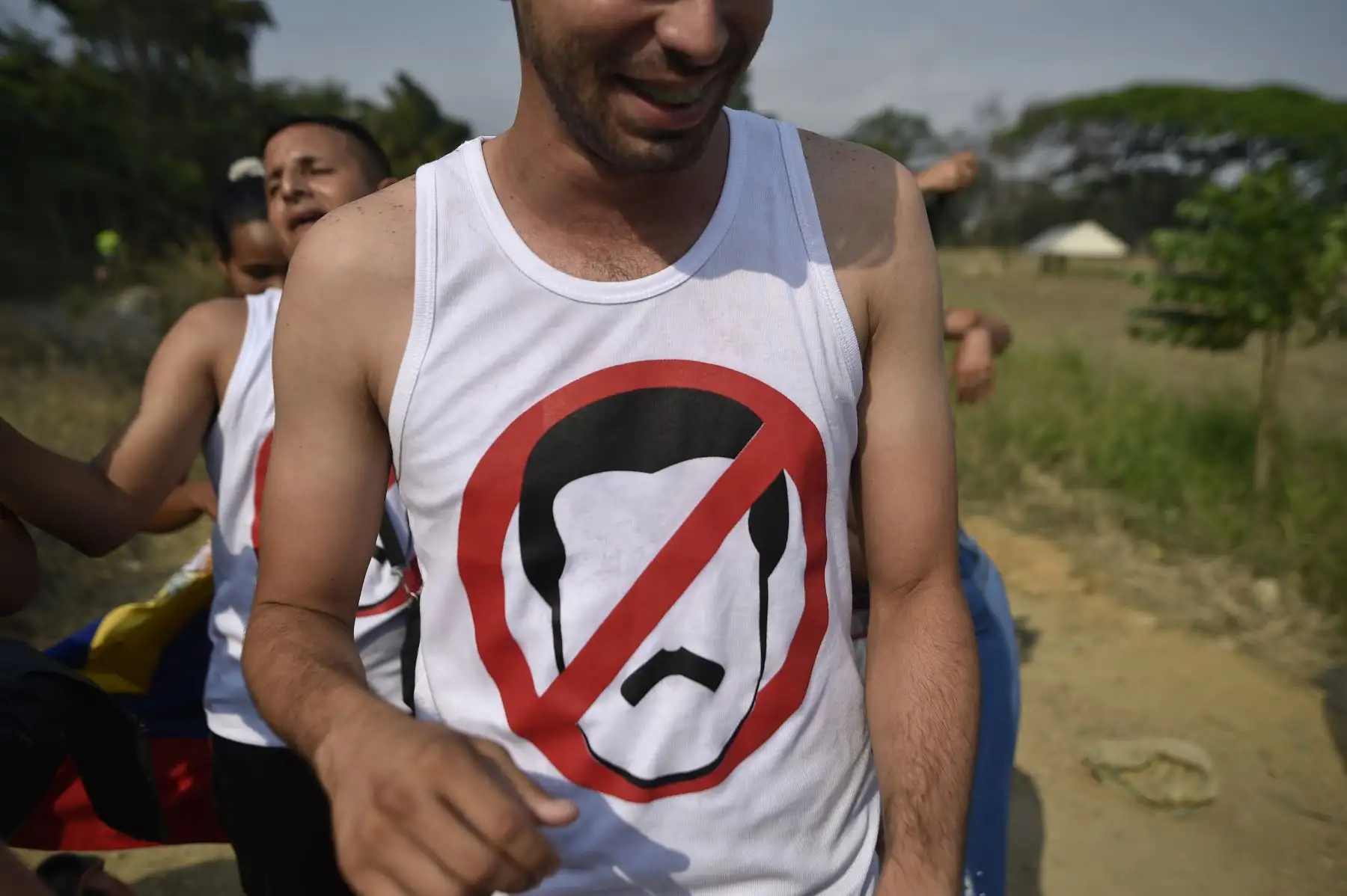 Un hombre usa una camiseta anti-Maduro mientras camina hacia el lugar donde se lleva a cabo el concierto "Venezuela Aid Live" en el Puente Internacional Tienditas en Cucuta, Colombia. El concierto fue organizado por el multimillonario británico Richard Branson para recaudar dinero para el esfuerzo de socorro venezolano. La lucha política de Venezuela se transforma en una batalla de bandas el viernes, con duelos de gobierno y conciertos pop de la oposición antes de un enfrentamiento de fin de semana sobre la