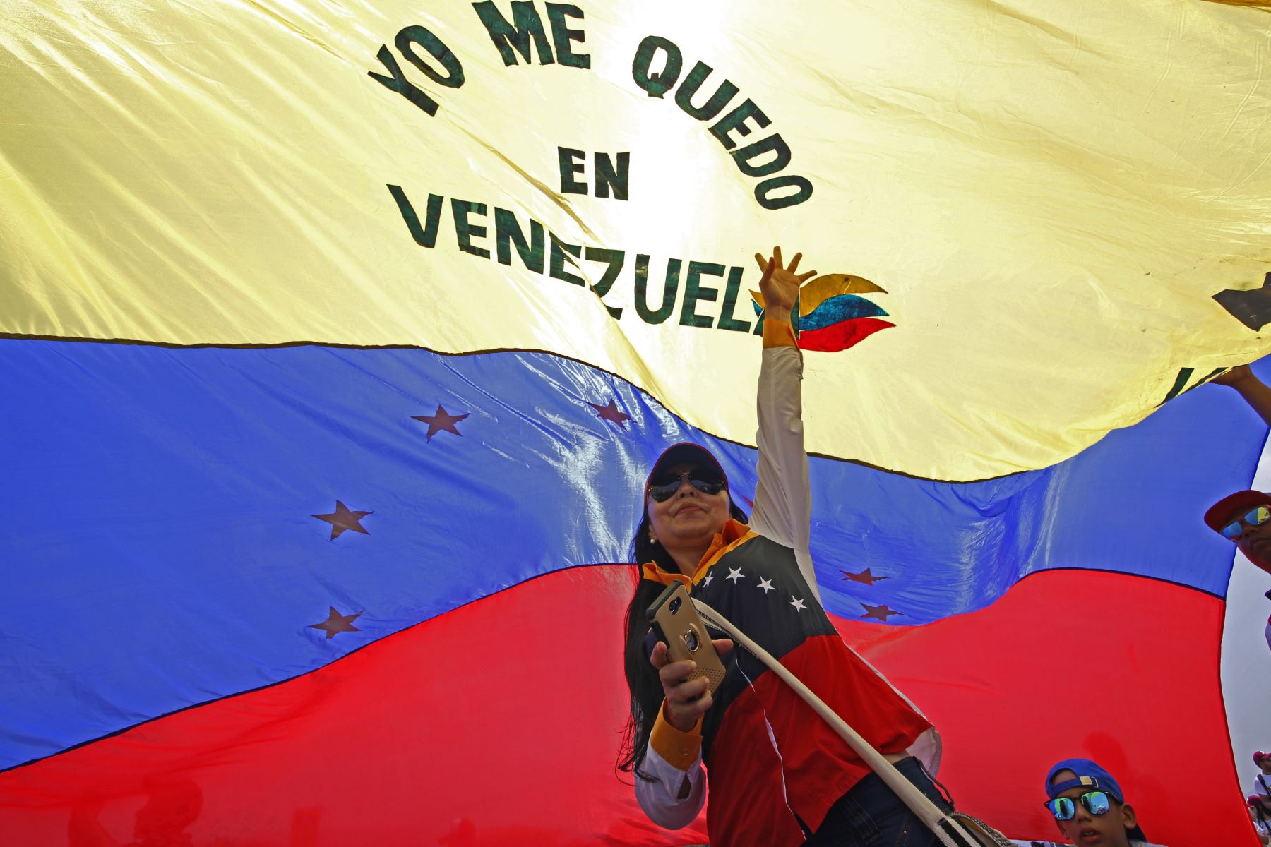 Una mujer sostiene una bandera venezolana mientras participaba en el concierto "Venezuela Aid Live". AFP