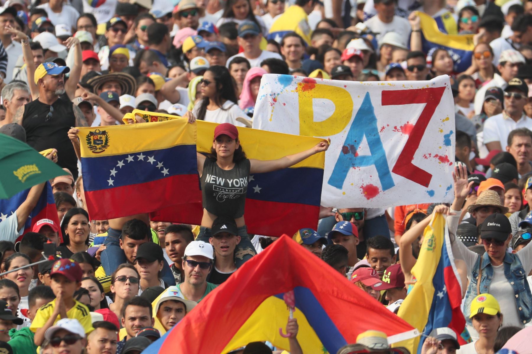 Miles de personas, muchas banderas venezolanas ondulantes asisten al conciertos en la frontera entre Venezuela y Colombia el viernes para un concierto benéfico internacional para impulsar las entregas de ayuda humanitaria en desafío al bloqueo del gobierno del presidente Nicolás Maduro. EFE