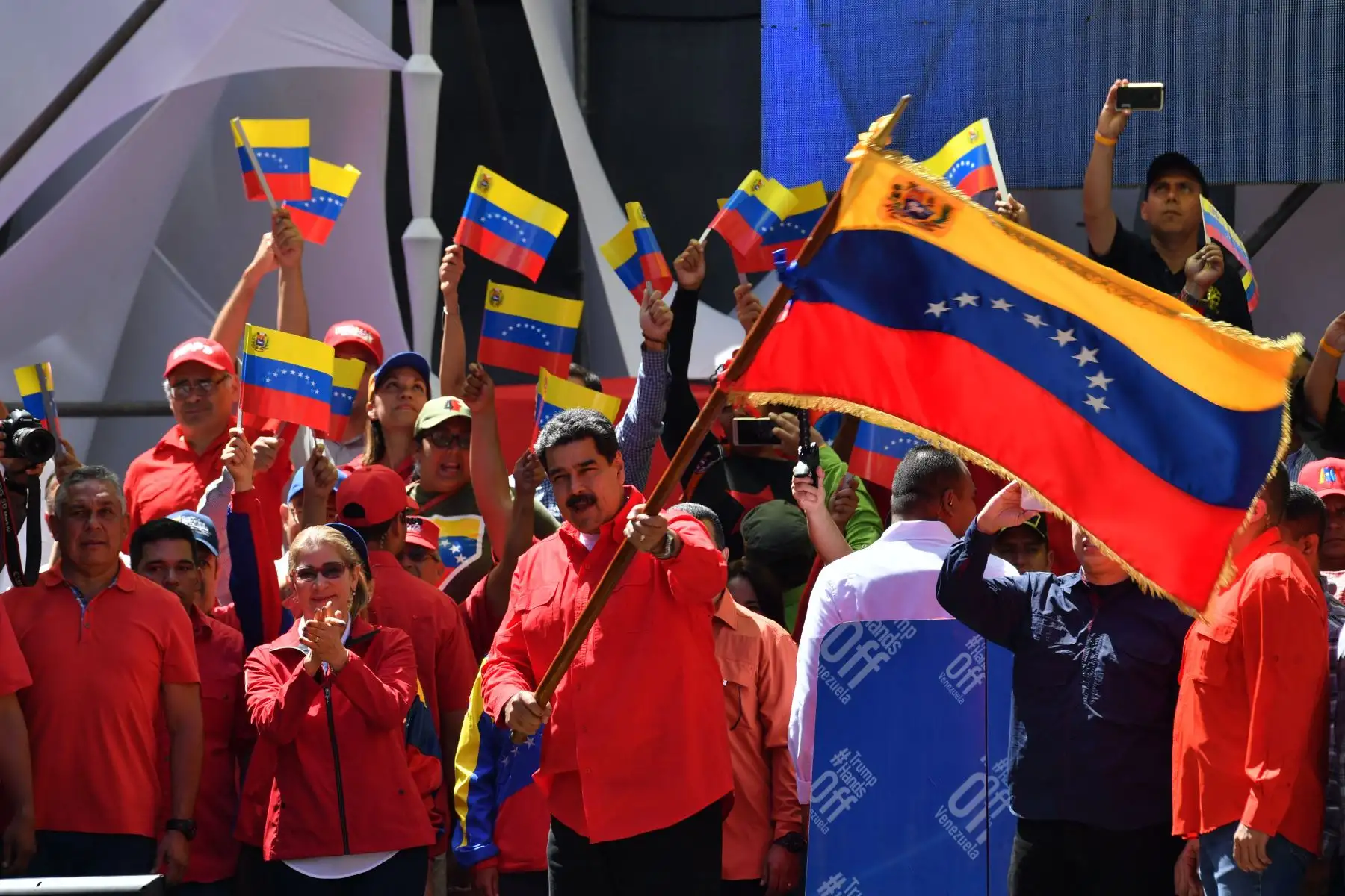 El  Nicolás Maduro  ondea la bandera nacional durante una marcha oficialista en Caracas, mientras en la frontera entre Venezuela y Colombia ordenó impedir el paso de la ayuda humanitaria . AFP