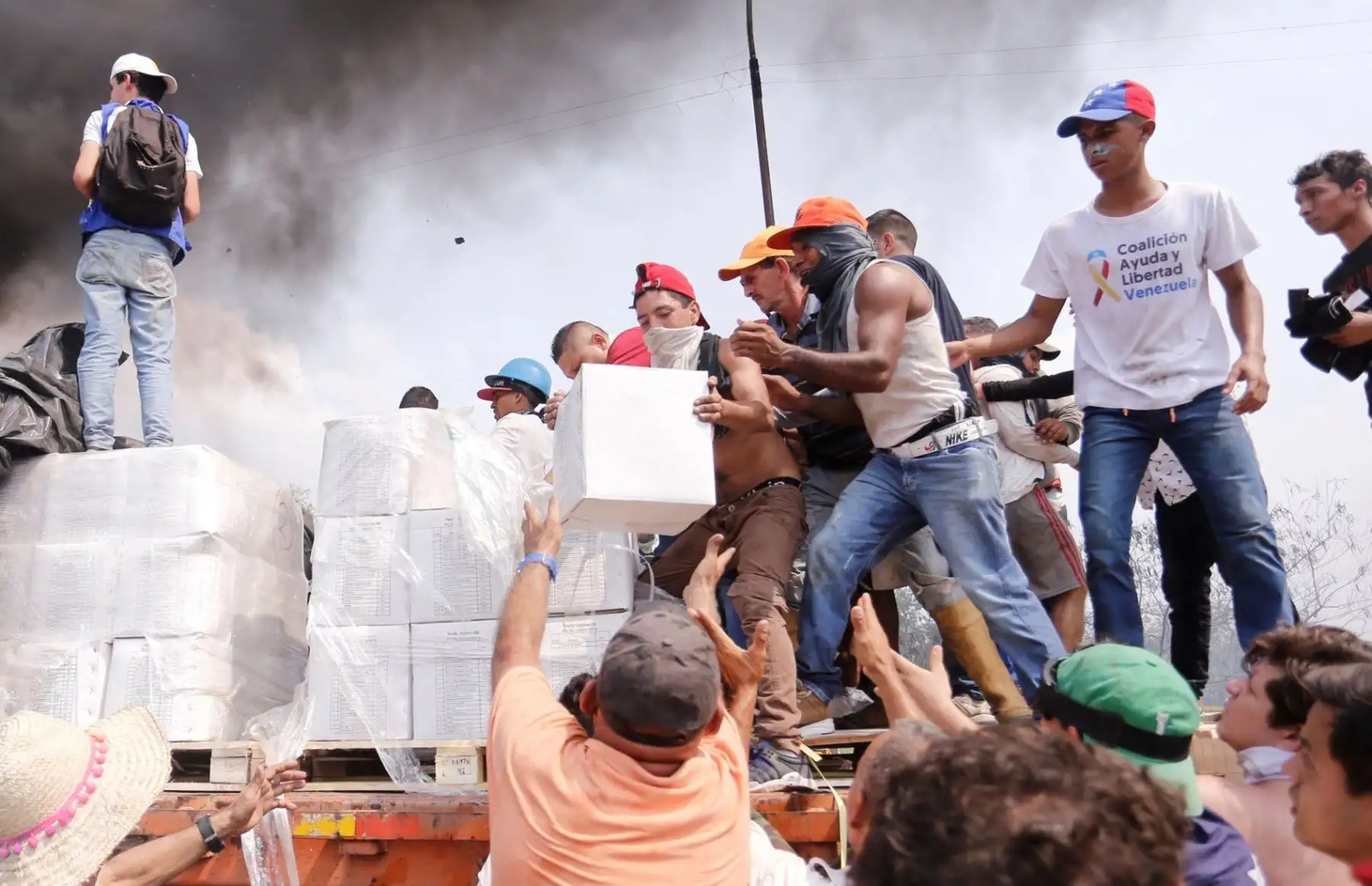 Personas intentan sacar parte de la ayuda humanitaria que se encuentra un camión que fue quemado,  en UreÒa (Venezuela). Dos camiones con ayuda humanitaria solicitada por la oposición fueron quemados por la PolicÌa Nacional Bolivariana en el lado venezolano del puente Francisco de Paula Santander, que conecta al paÌs con Colombia, denunció la diputada Gaby Arellano. EFE