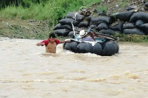 Algunos pobladores utilizan neumáticos para cruzar temerariamente el crecido río Zaña, a la altura del distrito de Oyotún.