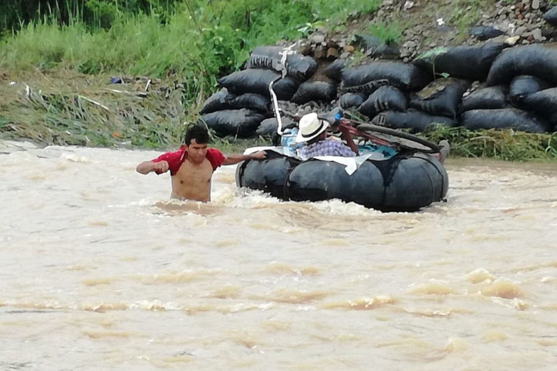 Algunos pobladores utilizan neumáticos para cruzar temerariamente el crecido río Zaña, a la altura del distrito de Oyotún.