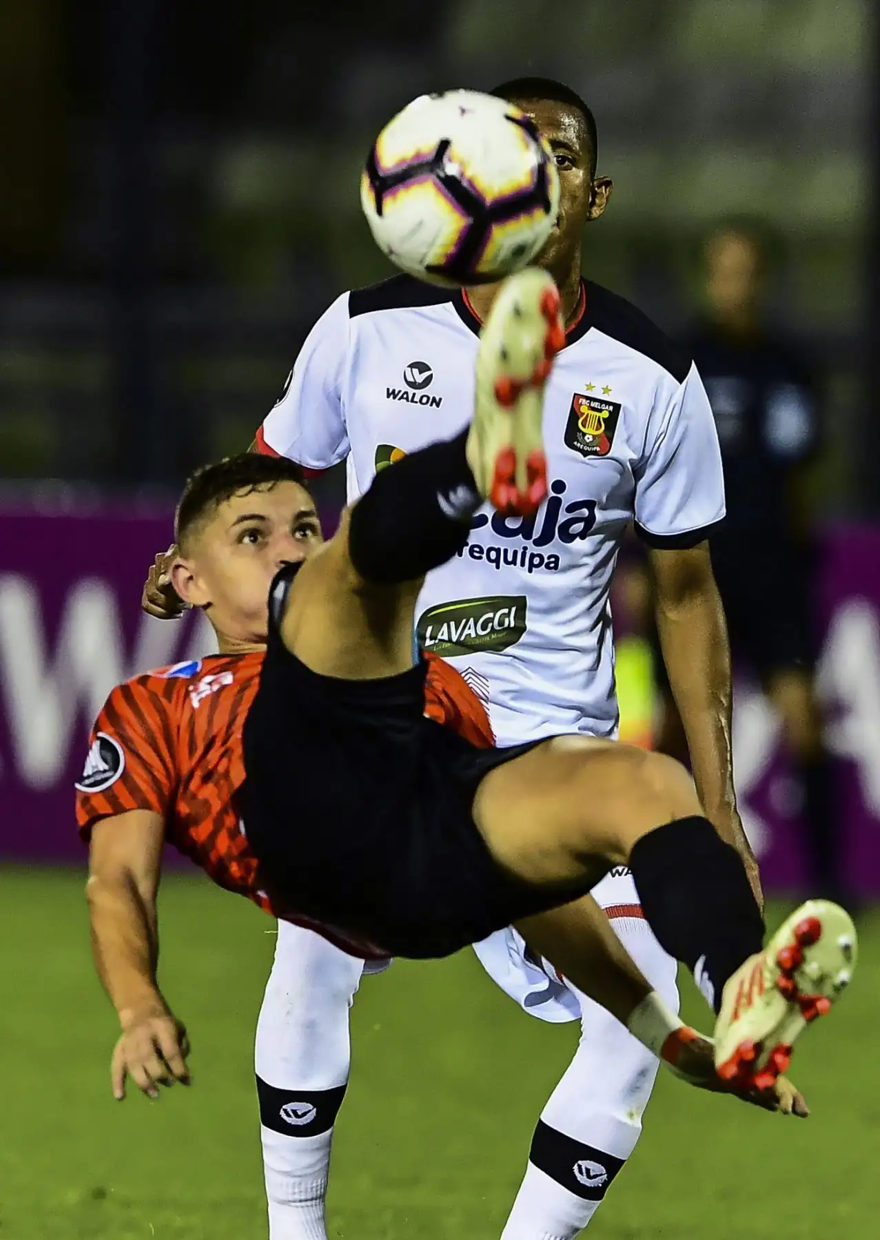 Eduardo Fereira (frente) de Caracas de Venezuela golpeó el balón en el aire mientras Johnny Vidales de Melgar de Perú observa durante su partido de fútbol de tercera etapa de la tercera fase de Copa Libertadores en el Estadio Olímpico de Caracas. AFP