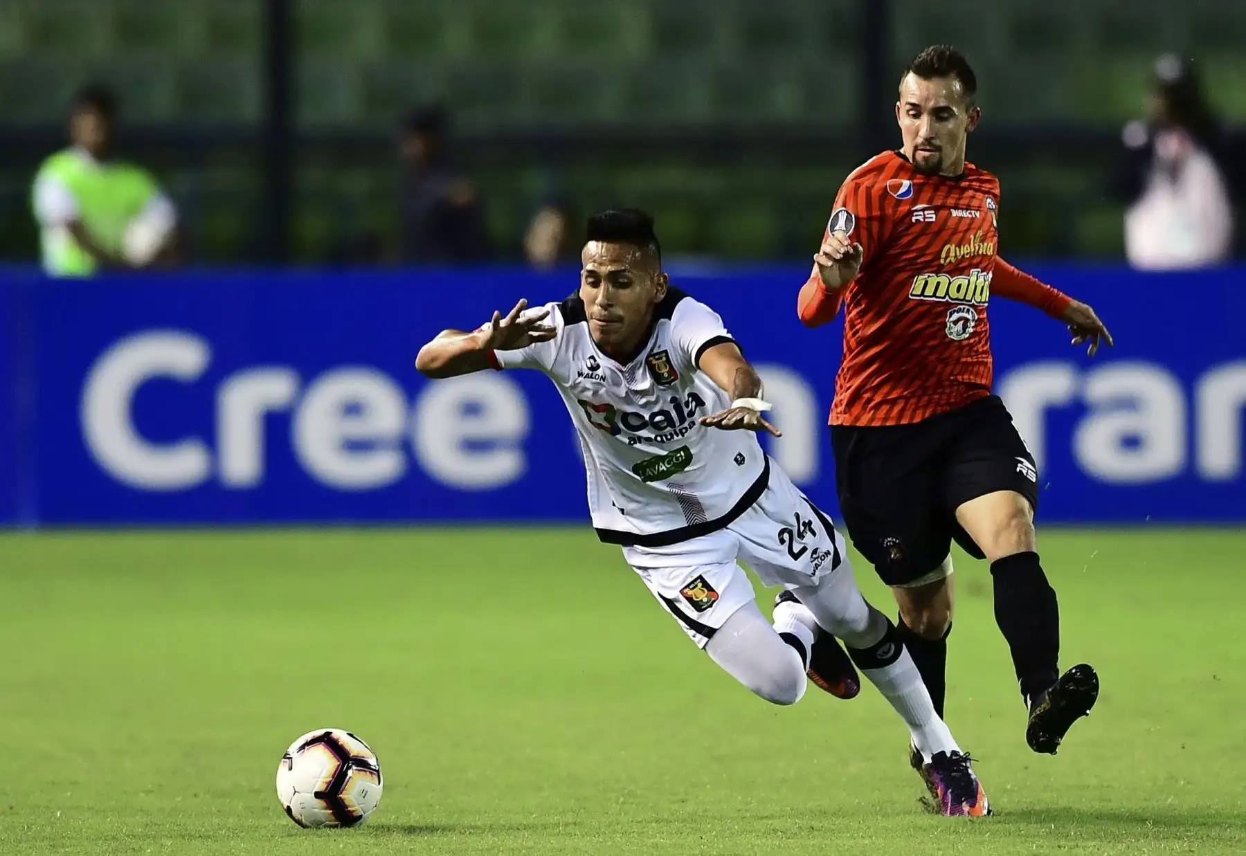 Carlos Neyra (L), de Melgar, de Perú, cae al lado de Robert Hernández de Caracas, de Venezuela, durante su partido de fútbol de la tercera fase de la tercera fase de la Copa Libertadores en el Estadio Olímpico de Caracas. AFP