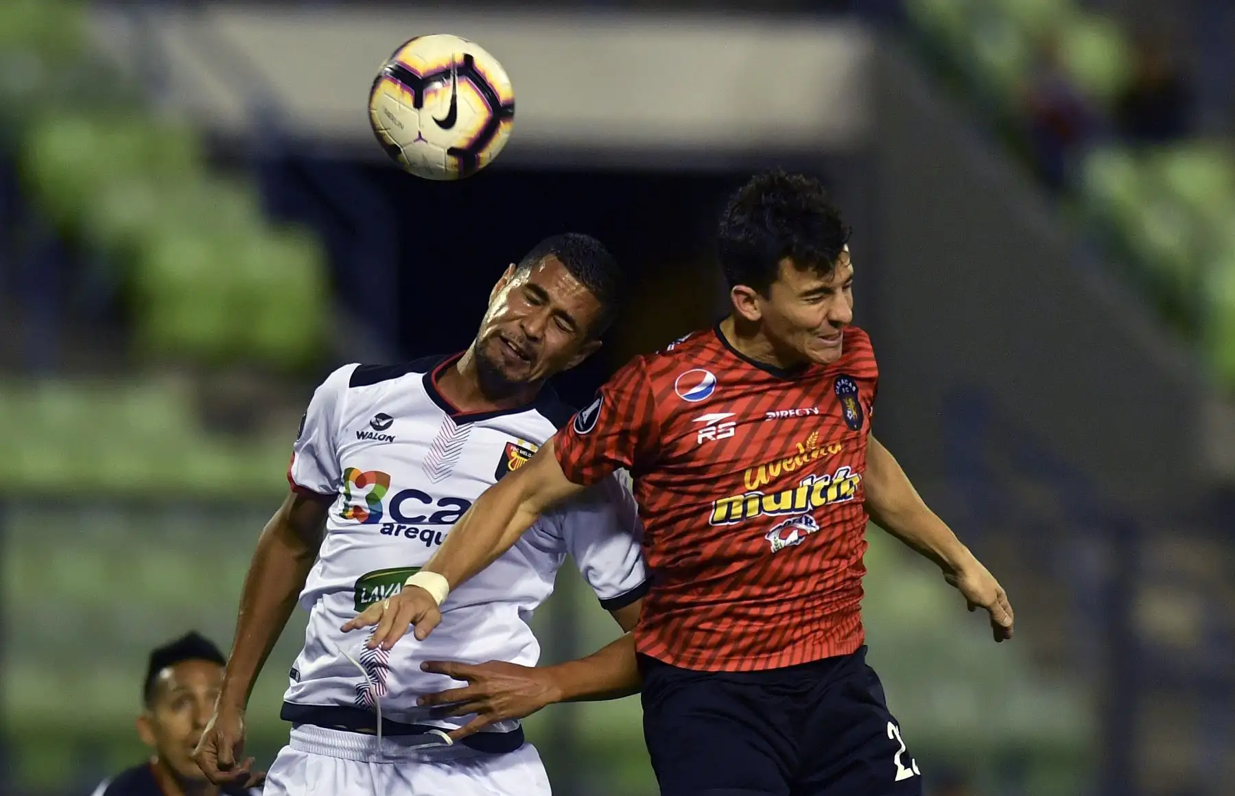 Bernardo Anor (R), mediocampista del Caracas de Enezuela, compite por el balón con el defensor Melgar del Perú David Villalba durante su partido de fútbol de la tercera fase de la tercera fase de la Copa Libertadores en el Estadio Olímpico en Caracas. AFP