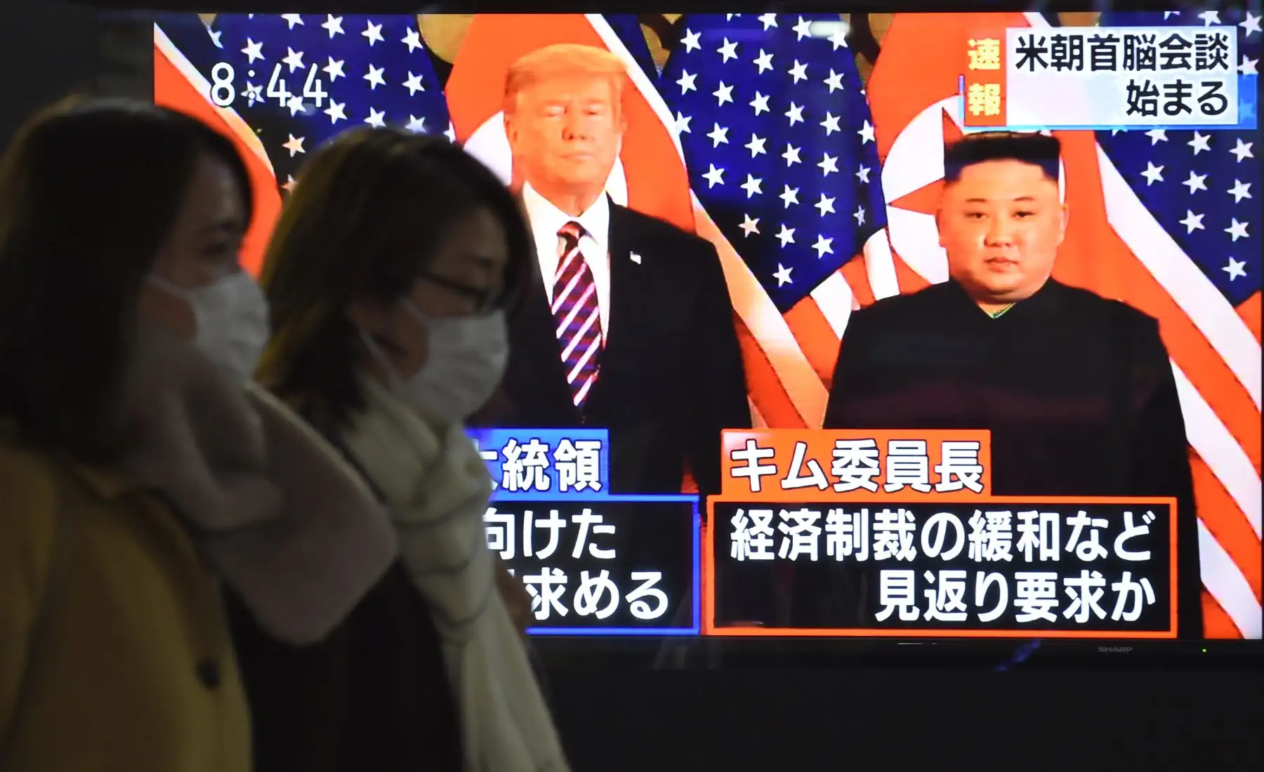 Los peatones pasan por una pantalla de televisión en Tokio que muestra una transmisión de noticias en la reunión cumbre entre el líder norcoreano Kim Jong Un y el presidente estadounidense Donald Trump en Hanoi. Foto: AFP/Kazuhiro Nogi