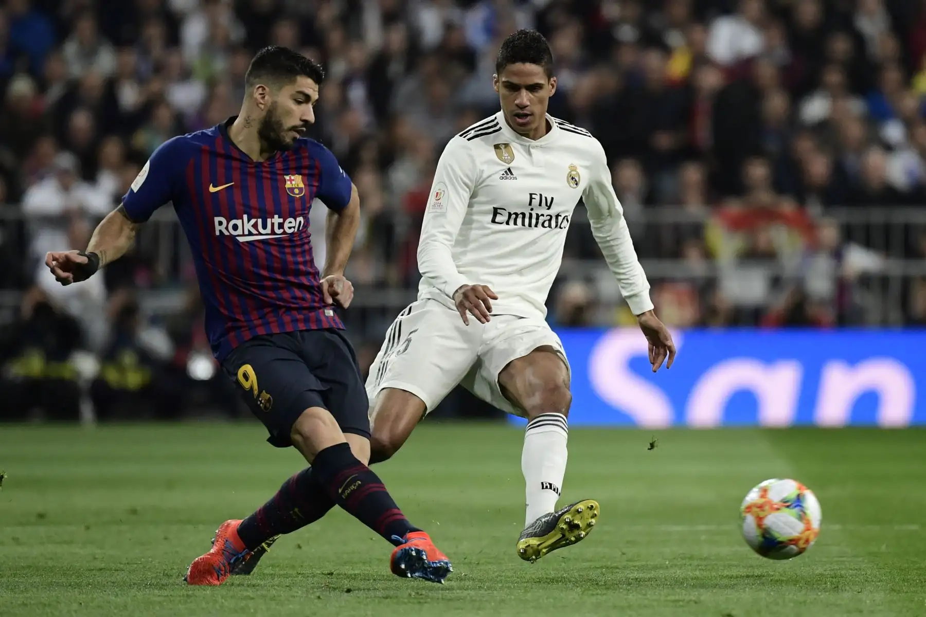 El delantero uruguayo del barcelonista Luis Suárez (L) compite con el defensa francés del Real Madrid, Raphael Varane, durante la semifinal de la segunda jornada de la Copa del Rey de España entre el Real Madrid y el Barcelona en el estadio Santiago Bernabeu de Madrid. Foto: AFP