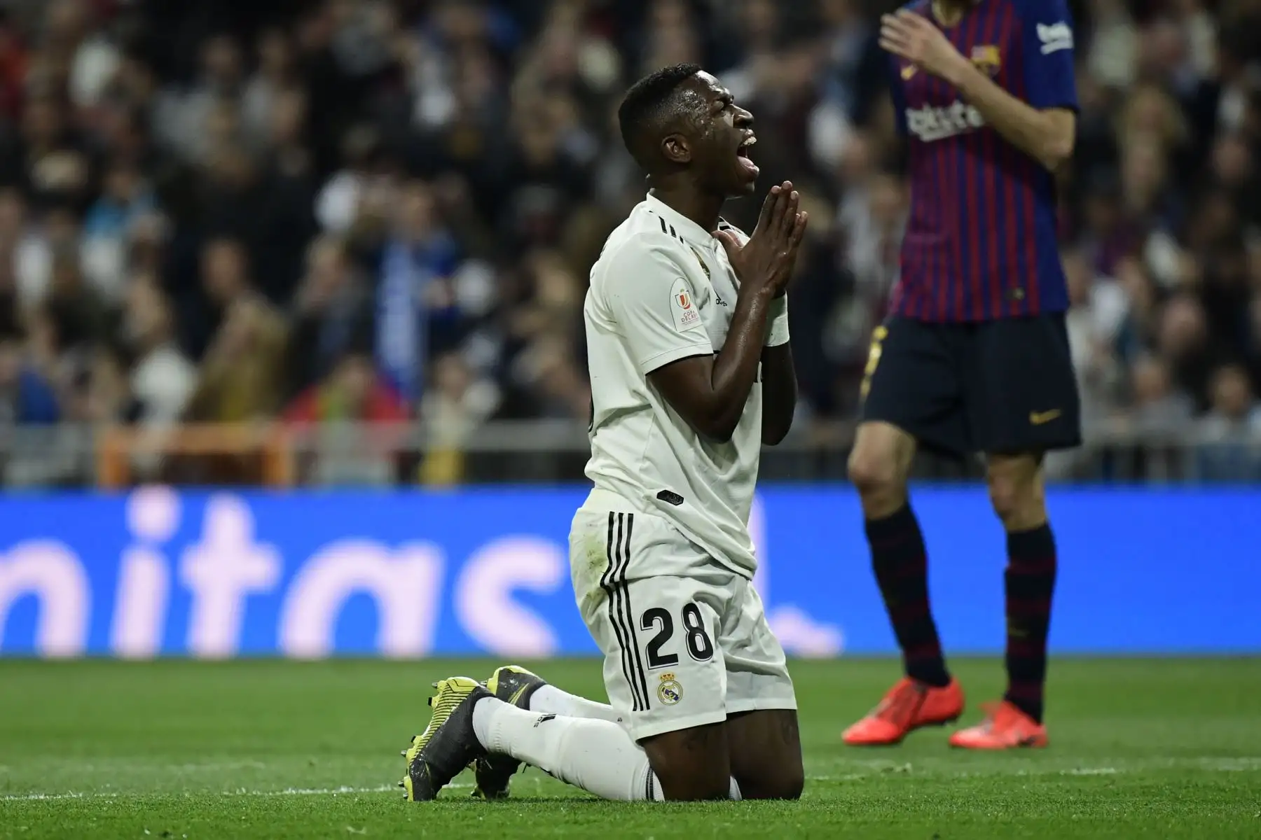 El delantero brasileño del Real Madrid, Vinicius Junior, se arrodilla en el campo durante la semifinal de la Copa del Rey (partido de la Copa del Rey) en el partido de fútbol de ida entre el Real Madrid y el Barcelona en el estadio Santiago Bernabeu de Madrid. AFP