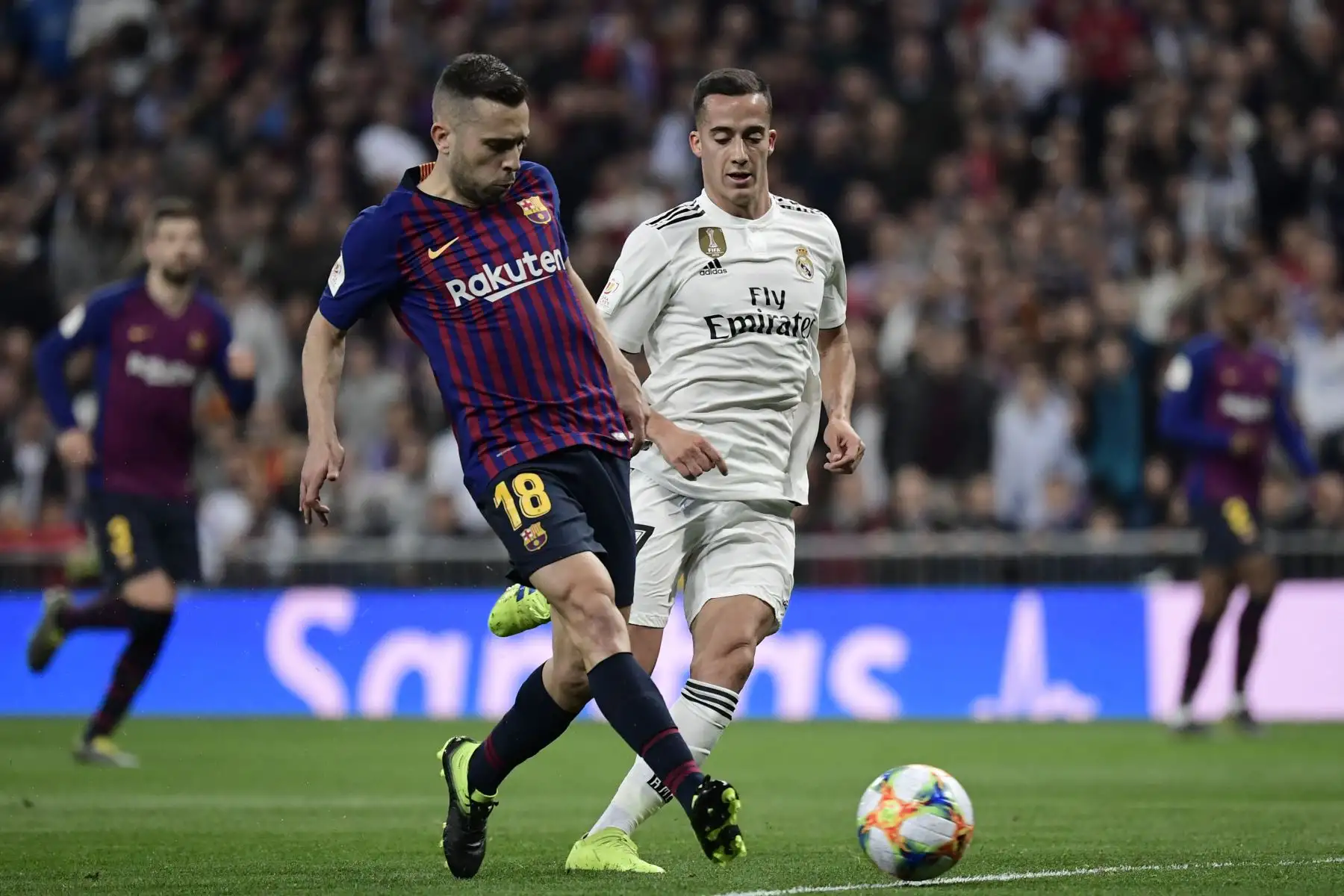 El defensa del Barcelona, Jordi Alba (L) compite con el centrocampista español del Real Madrid, Lucas Vázquez, durante la semifinal de fútbol de la segunda etapa de la Copa del Rey de España entre el Real Madrid y el Barcelona en el estadio Santiago Bernabeu de Madrid.