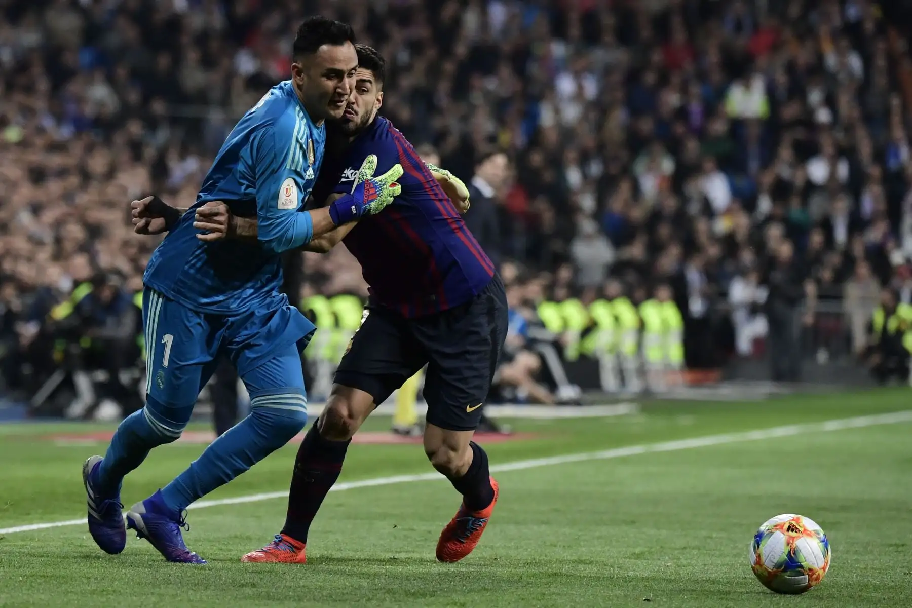 El delantero uruguayo del suizo Luis Suárez (R) compite con el portero costarricense del Real Madrid, Keylor Navas, durante la semifinal de la segunda jornada de la Copa del Rey de España entre el Real Madrid y el Barcelona en el estadio Santiago Bernabeu de Madrid. AFP