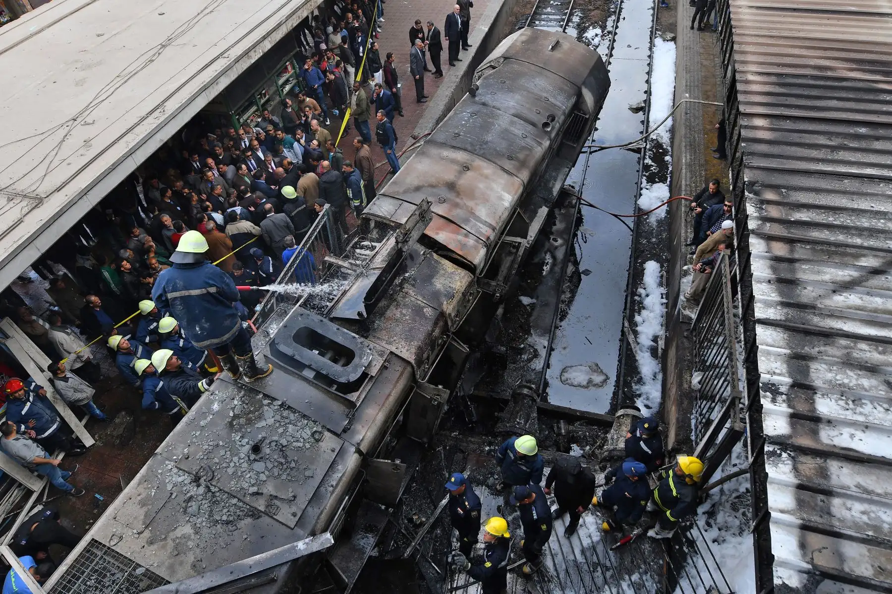 Bomberos y espectadores se reúnen en el lugar de un feroz accidente ferroviario en la estación de tren principal de la capital egipcia, El Cairo, el 27 de febrero de 2019. El accidente causó la muerte de al menos 20 personas, dijeron fuentes de seguridad y médicas egipcias. El accidente, que provocó un gran incendio en la estación de Ramses, también hirió a otros 40, dijeron las fuentes.Foto: AFP