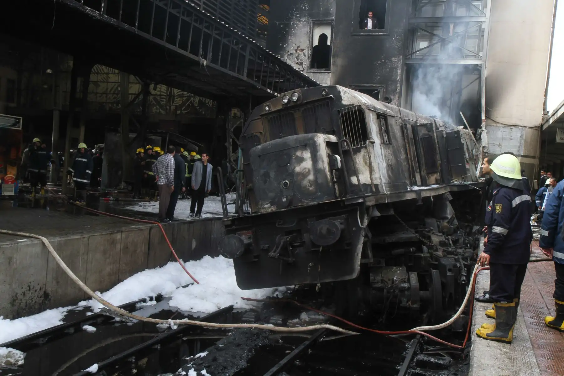 Bomberos y espectadores se reúnen en el lugar de un feroz accidente ferroviario en la estación de tren principal de la capital egipcia, El Cairo, el 27 de febrero de 2019. El accidente causó la muerte de al menos 20 personas, dijeron fuentes de seguridad y médicas egipcias. Foto: AFP