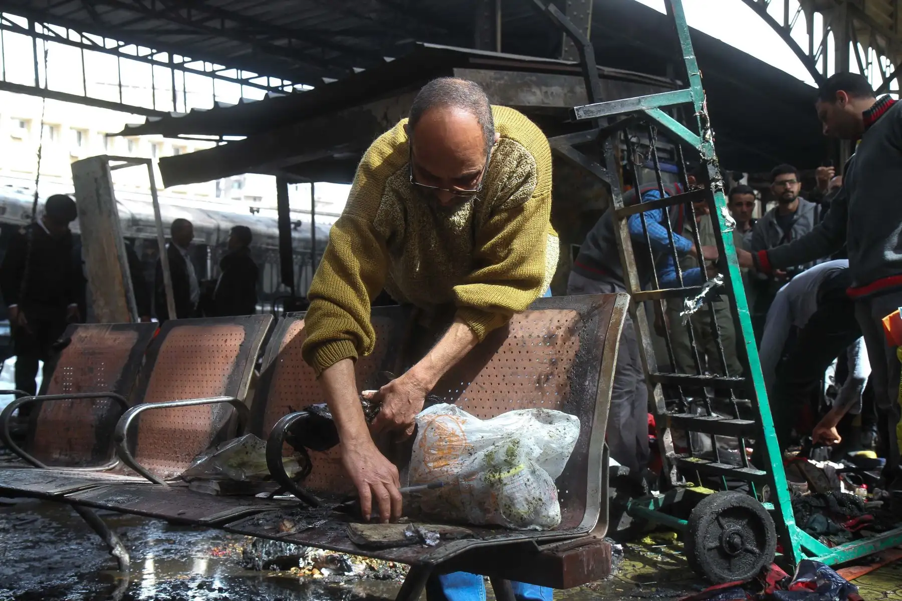 Un hombre despeja los objetos carbonizados en la escena de un choque de tren en la estación de tren principal de la capital egipcia, El Cairo, el 27 de febrero de 2019. El accidente causó la muerte de al menos 20 personas, dijeron fuentes de seguridad y médicas egipcias. Foto: AFP