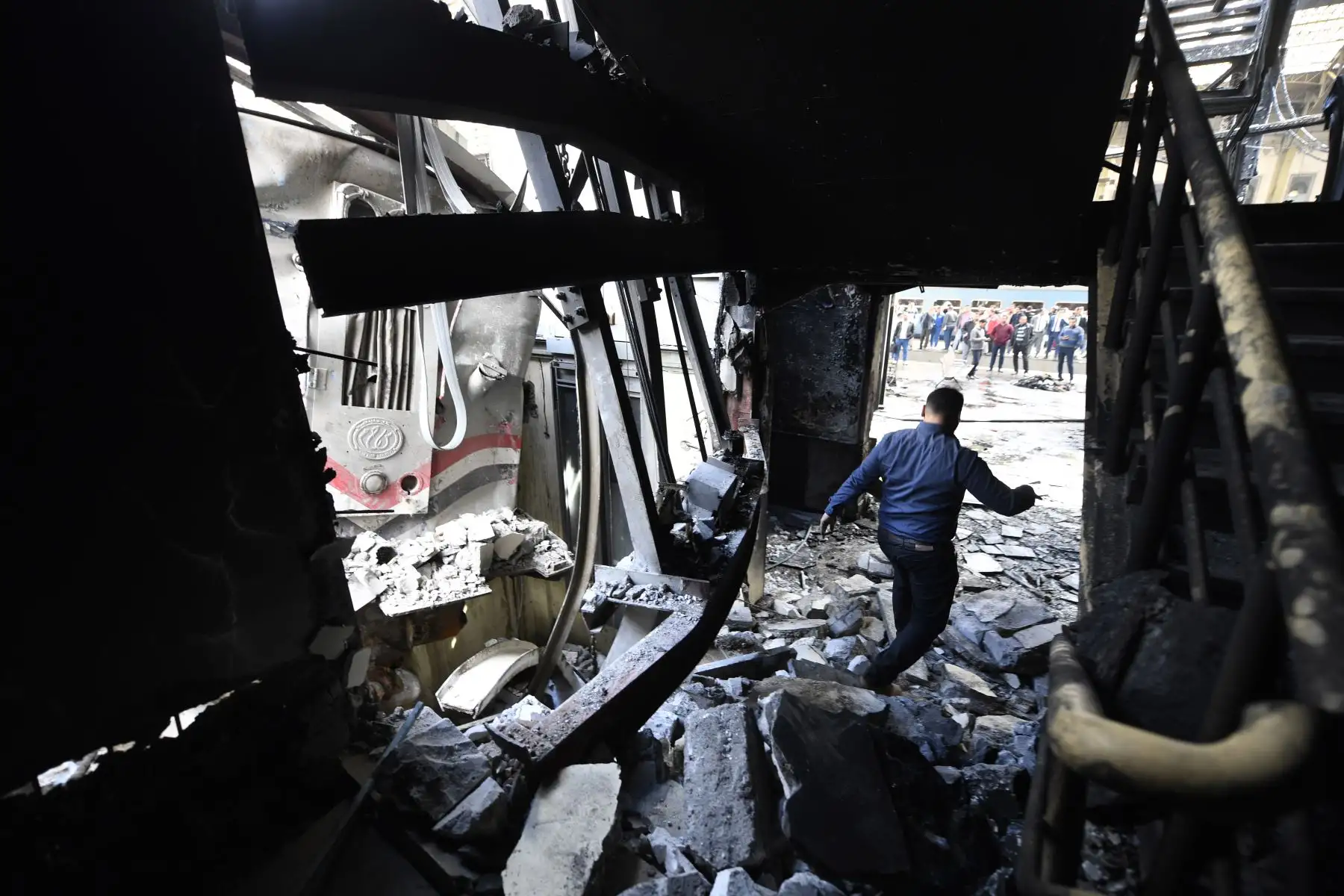 Un hombre camina sobre escombros en la escena de un choque de tren en la estación de tren principal de la capital egipcia, El Cairo, el 27 de febrero de 2019. El accidente causó la muerte de al menos 20 personas, dijeron fuentes de seguridad y médicas egipcias. Foto: AFP