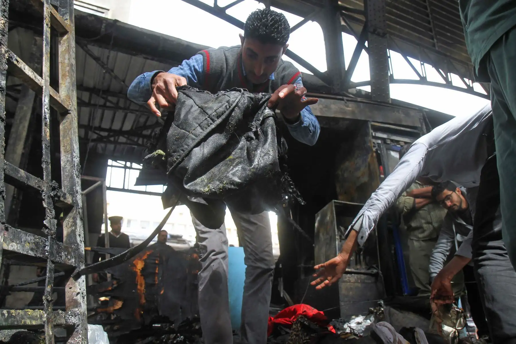 Un hombre quita un artículo de ropa de la escena de un choque de tren en la estación de tren principal de la capital egipcia, El Cairo, el 27 de febrero de 2019. El accidente causó la muerte de al menos 20 personas, dijeron fuentes de seguridad y médicas egipcias. Foto: AFP