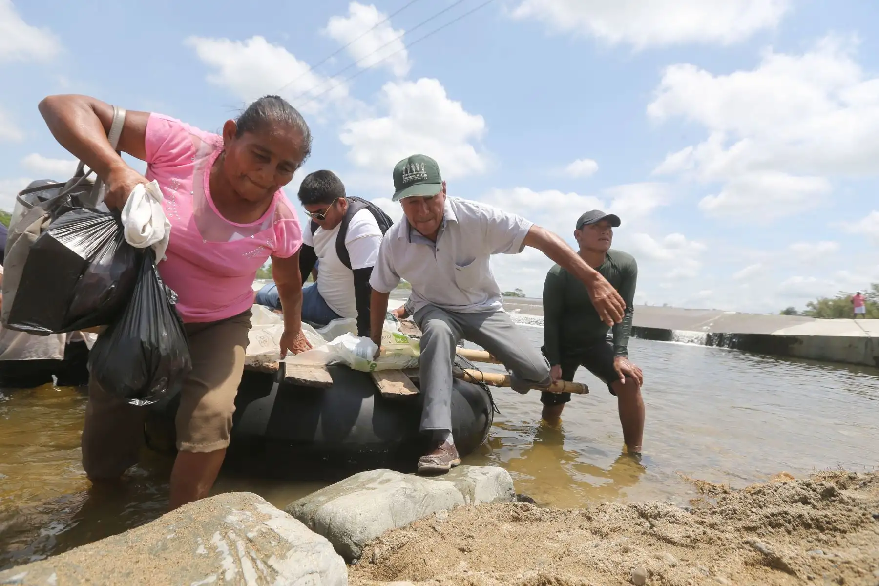 Vecinos de Malingas, centro poblado aislado por la activación de la quebrada San Francisco que dañó la vía hacia Tambogrande (Piura), cruzan en botes provisionales. Foto: ANDINA/ jhony Laurente
