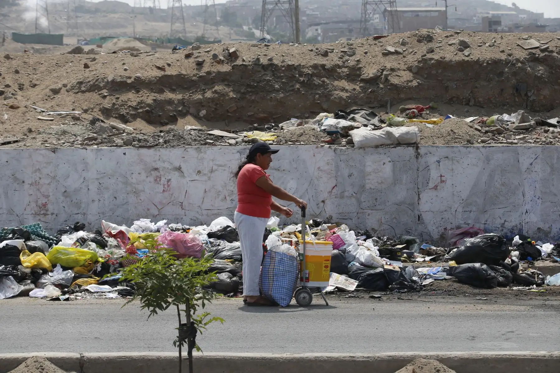 Street Photo Lima, Perú. Frente a un cúmulo de basura, mujer espera colectivo.   Foto: ANDINA/Nathalie Sayago