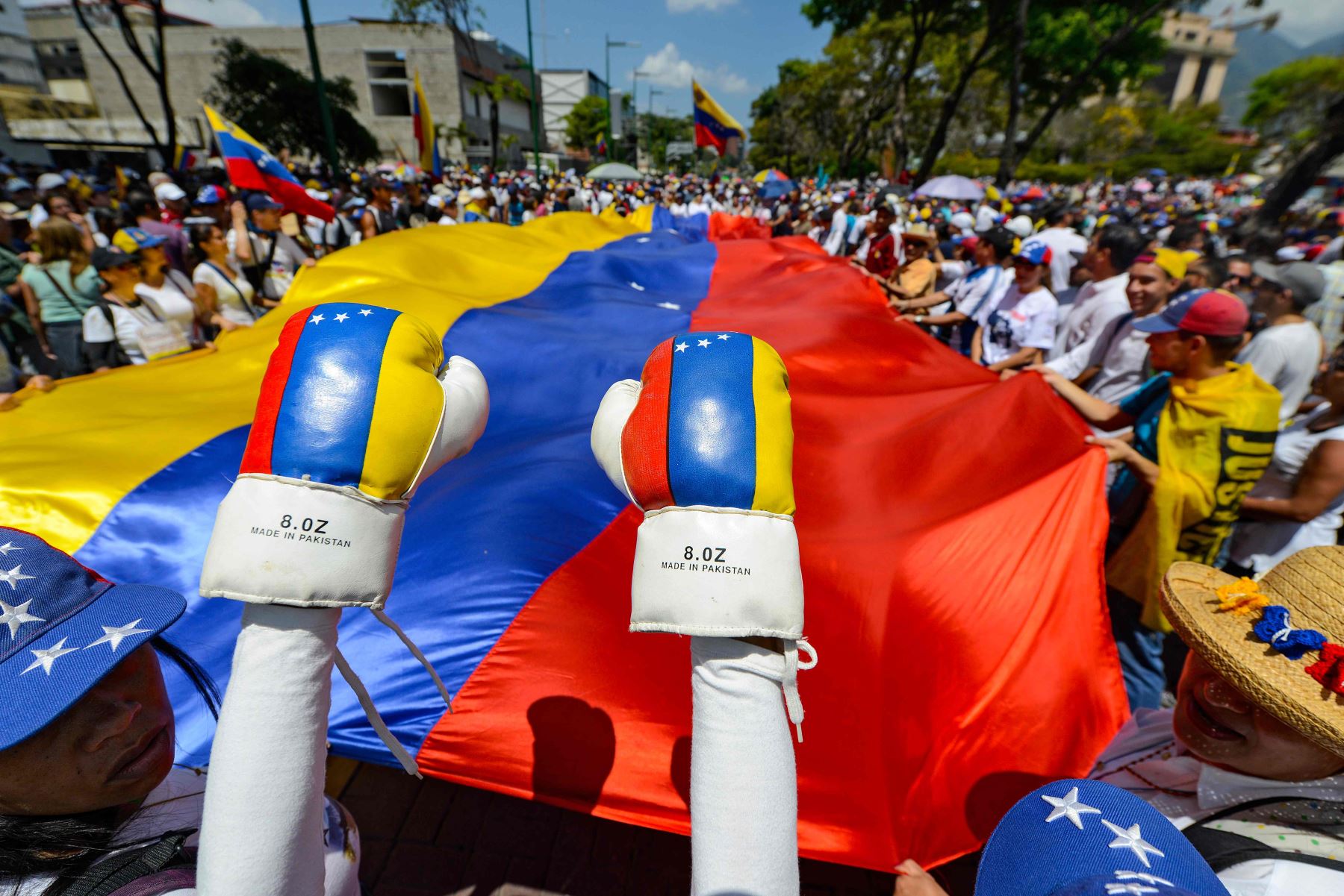 Simpatizantes del líder opositor venezolano y autoproclamado presidente en funciones, Juan Guaido se manifiestan con una bandera nacional venezolana gigante. Foto: AFP