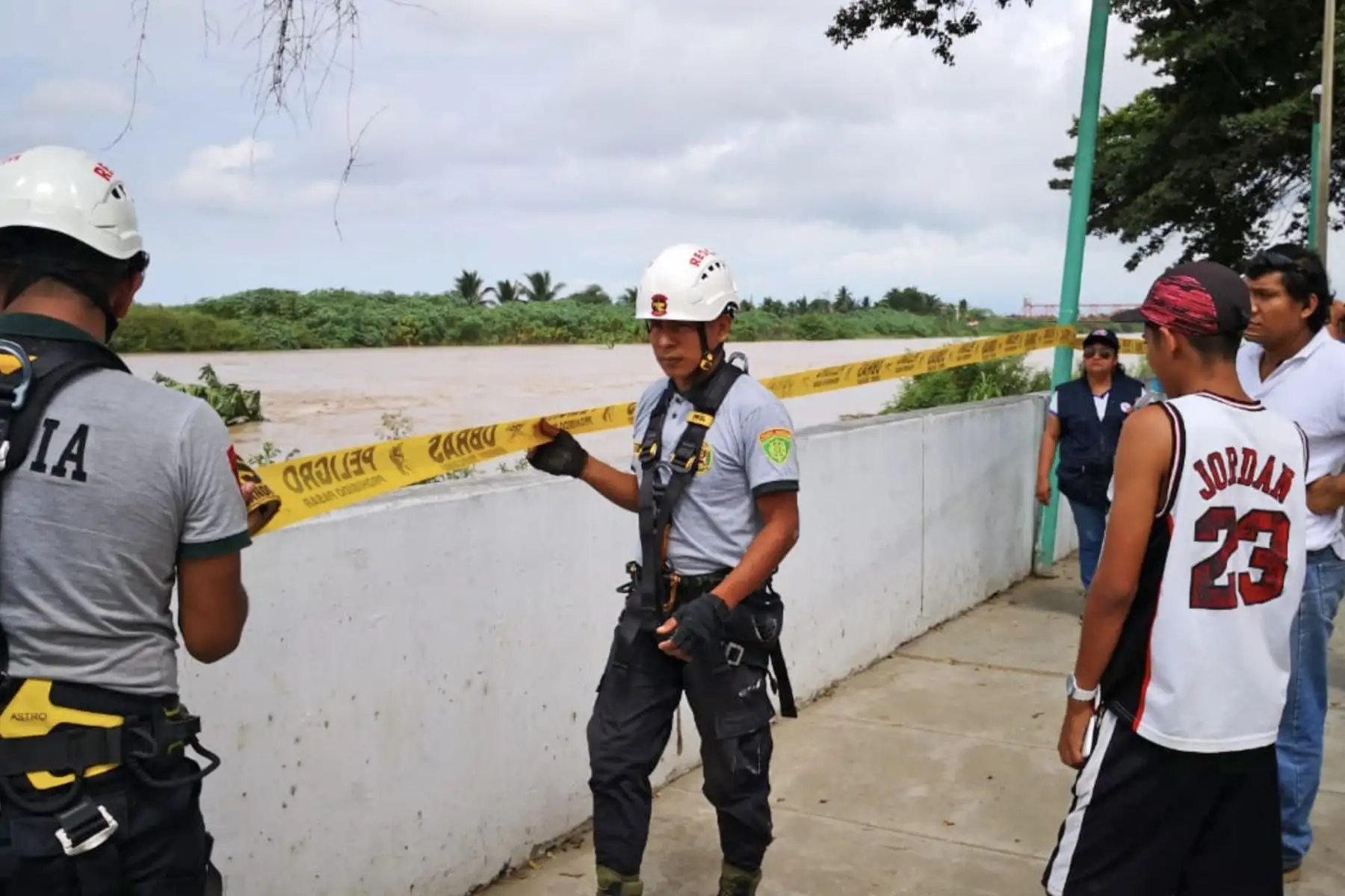 Agentes de la Policía Nacional y miembros del Serenazgo de Tumbes tratan de retirar a decenas de personas que se han ubicado cerca de la ribera del río Tumbes . Foto: ANDINA