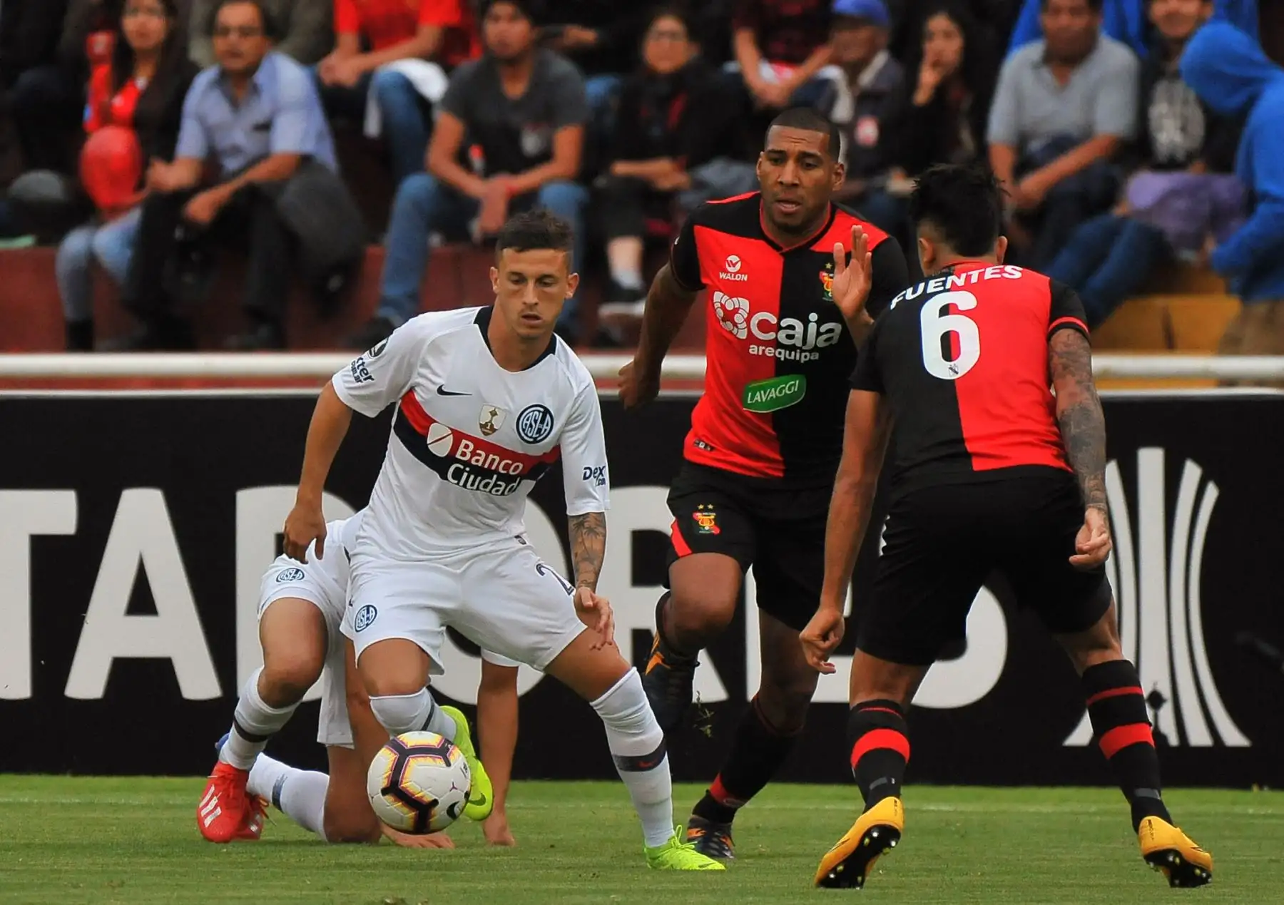Héctor Fertoli de San Lorenzo, de Argentina, compite por el balón con Giancarlo Carmona, de Melgar, de Perú. Foto: AFP