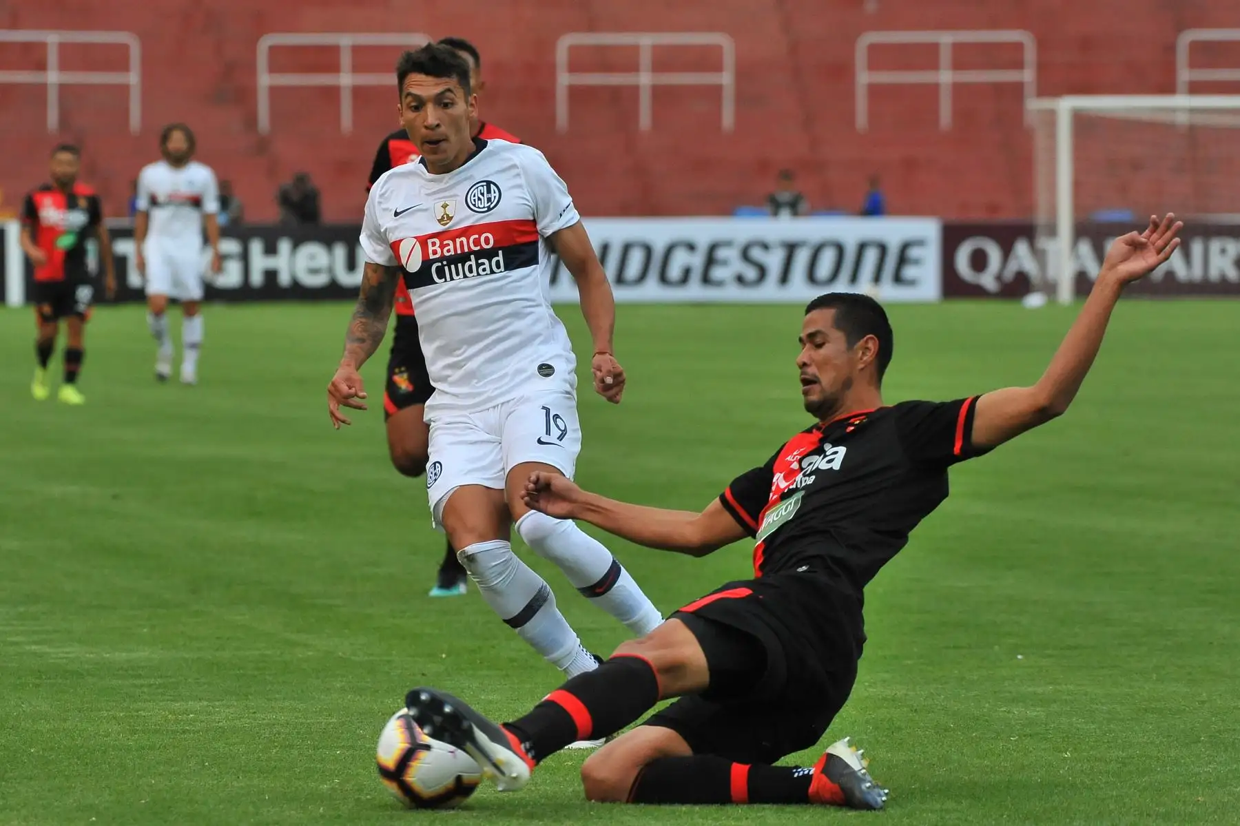 Rubén Botta de San Lorenzo, de Argentina, compite por el balón con David Villalba, de Melgar, de Perú, durante su partido de fútbol de la Copa Libertadores. Foto: AFP