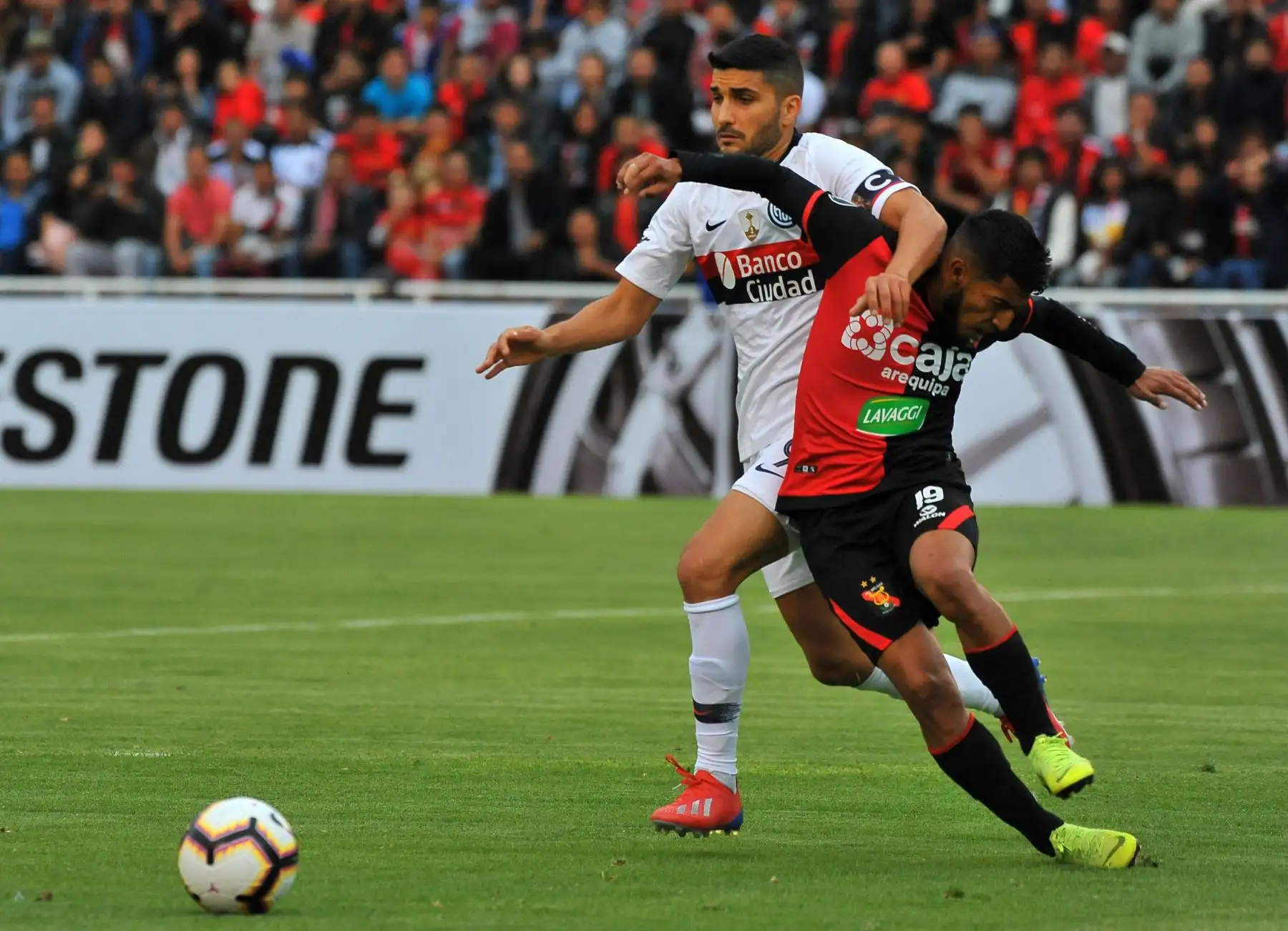 Nicolas Blandi de San Lorenzo de Argentina compite por el balón con Alexis Arias de Melgar de Perú durante su partido de fútbol de la Copa Libertadores. Foto: AFP